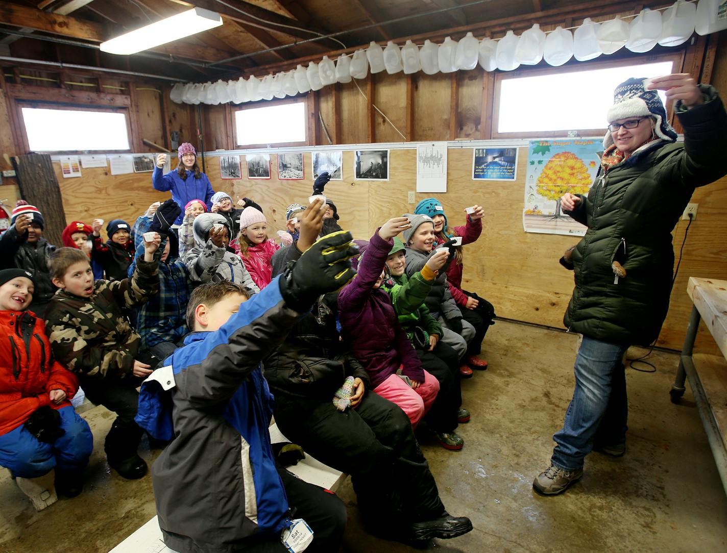 Youth educator Zeta Kilbride (right) of the Minnesota Landscape Arboretum and EXPO Elementary students taste maple sap in the sugarhouse at the Minnesota Landscape Arboretum. ] JOELKOYAMA&#x201a;&#xc4;&#xa2;jkoyama@startribune Chaska, MN on March 27, 2014. Photo of school kids learning about maple syrup program at the MN Landscape Arboretum. Can you get some shots of kids tasting the syrup? Also, please photograph Richard Devries, who heads the program, preferrably in the sugarhouse.