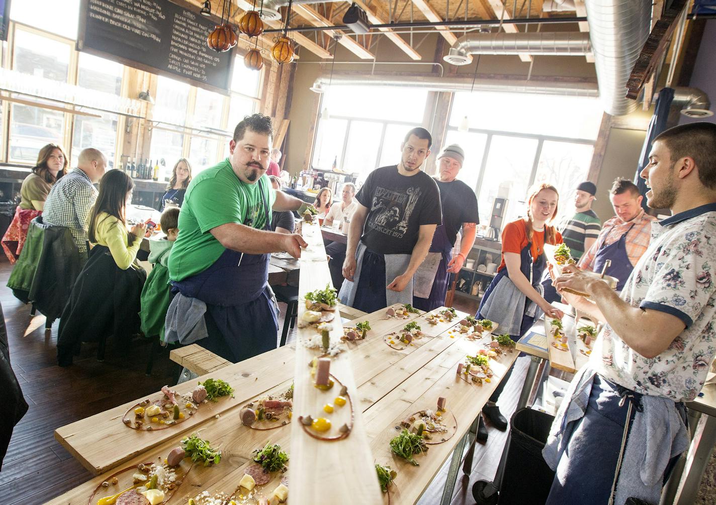 Co-owner and chef Mike Brown passes a charcuterie board to another chef for service to a table at Travail in Robbinsdale April 18, 2014. (Courtney Perry/Special to the Star Tribune)