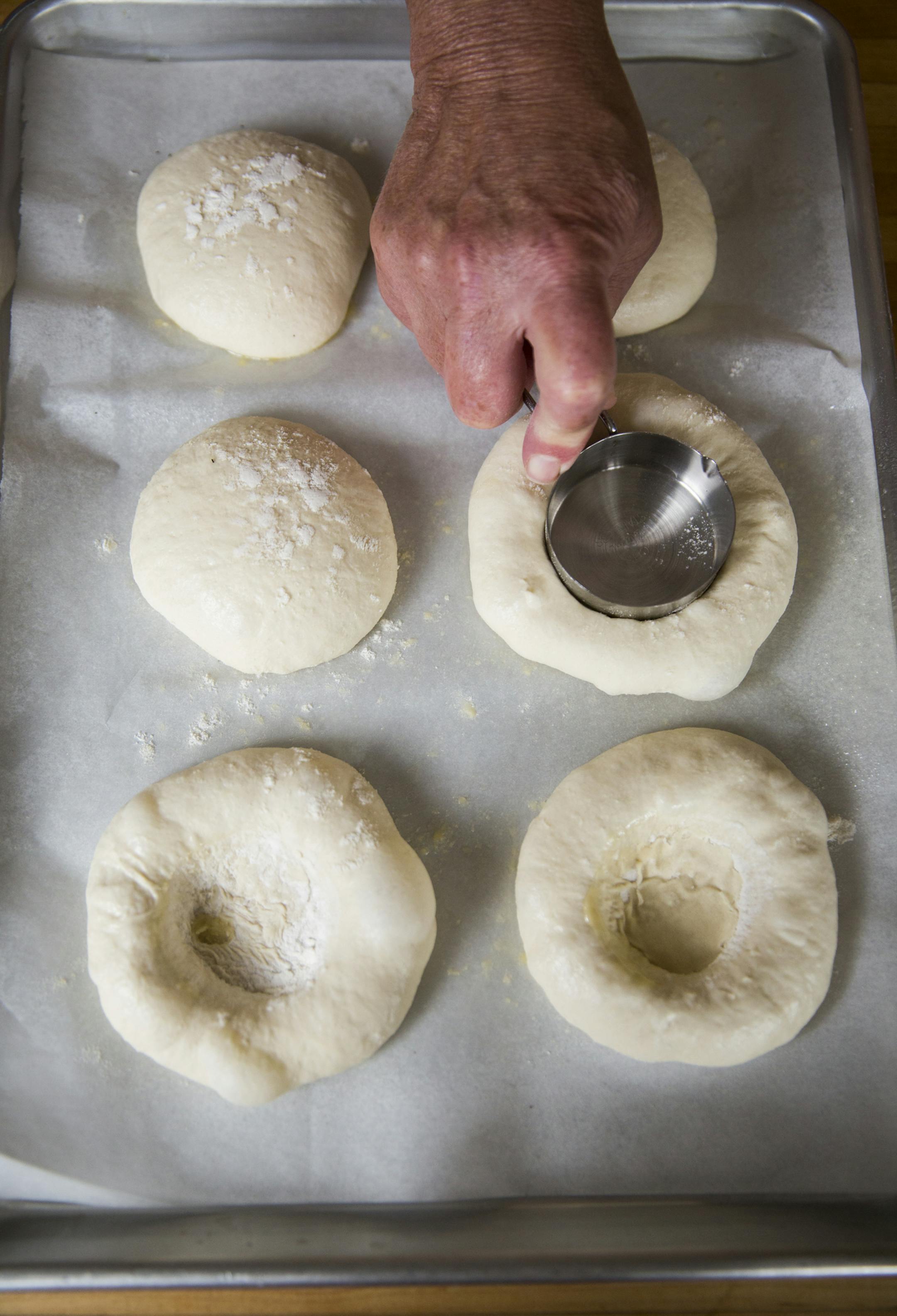 Make the indentations in the middle of the dough with the measuring cup. ] (Leila Navidi/Star Tribune) leila.navidi@startribune.com BACKGROUND INFORMATION: Baking Central makes bialys, an onion and poppyseed filled bread of Eastern European fame, on Thursday, September 15, 2016.