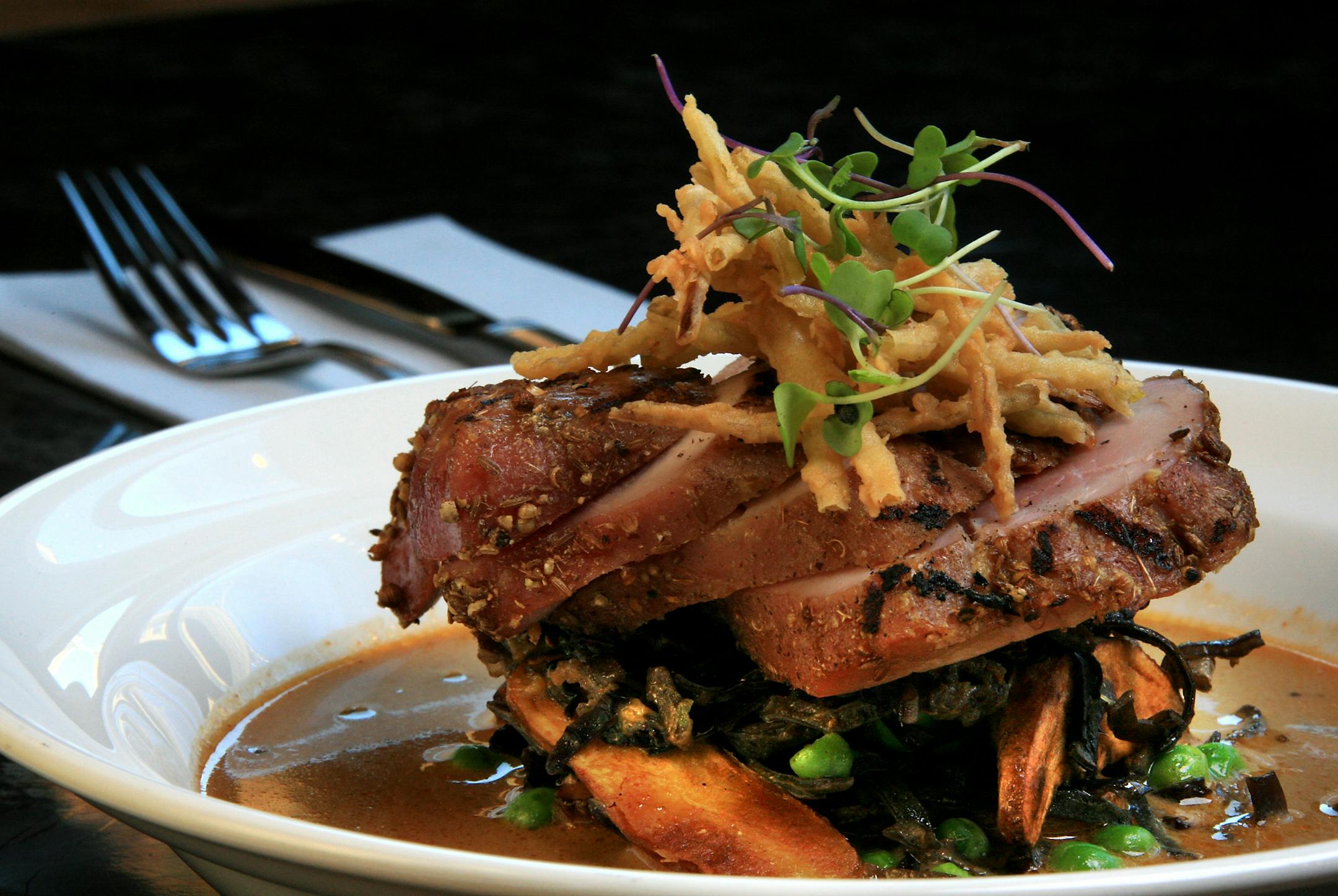 Pork tenderloin Massaman curry with fingerling potatoes, mushrooms, green peas, fried leeks and black zante currant.