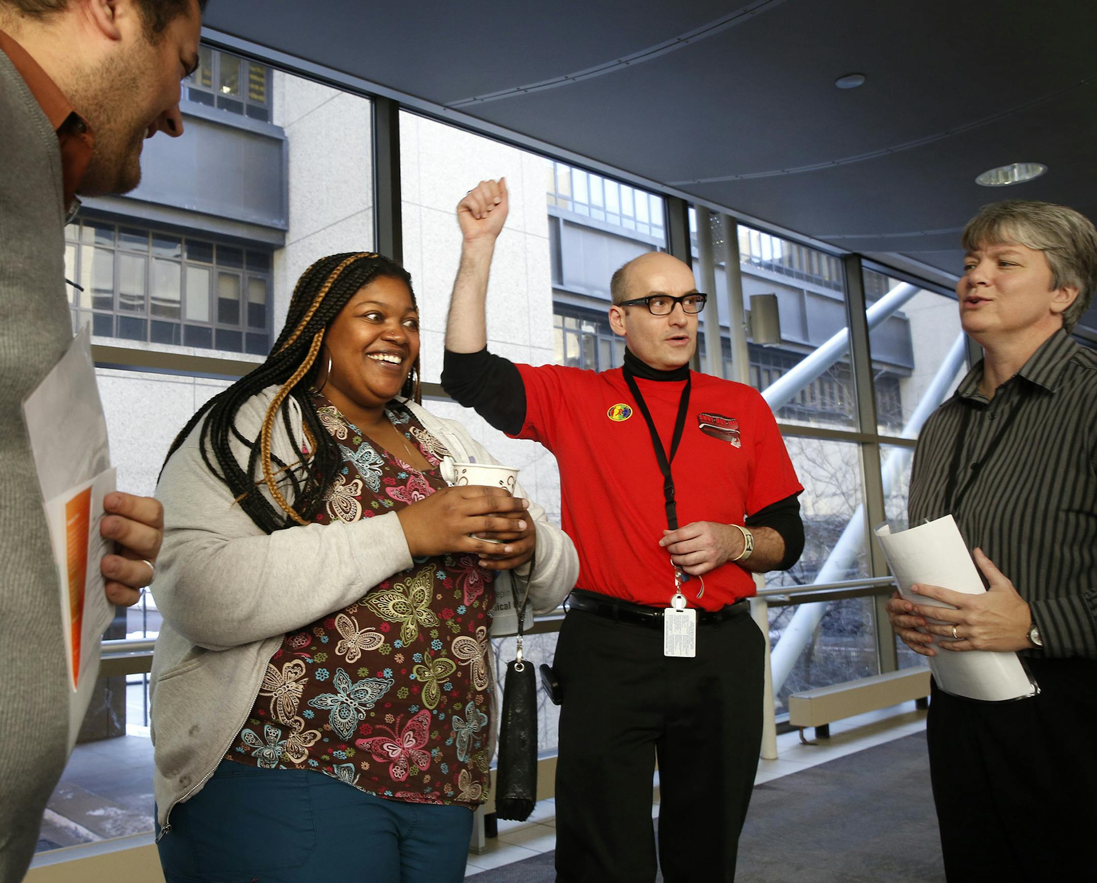 Camille Evans, second from left, a medical assistant at the Positive Care Center for HIV/AIDS patients at HCMC, plays a game during a World AIDS Day resource fair at Hennepin County Medical Center in Minneapolis on Monday, December 1, 2014. From left is Tony Yanni, a project manager at HCMC, Hank Jensen, eligibility coordinator at the Positive Care Center, and Jackie Zurn, who works for payroll at HCMC. The quiz tested people's knowledge of HIV/AIDS and the Positive Care Center for HIV/AIDS pati