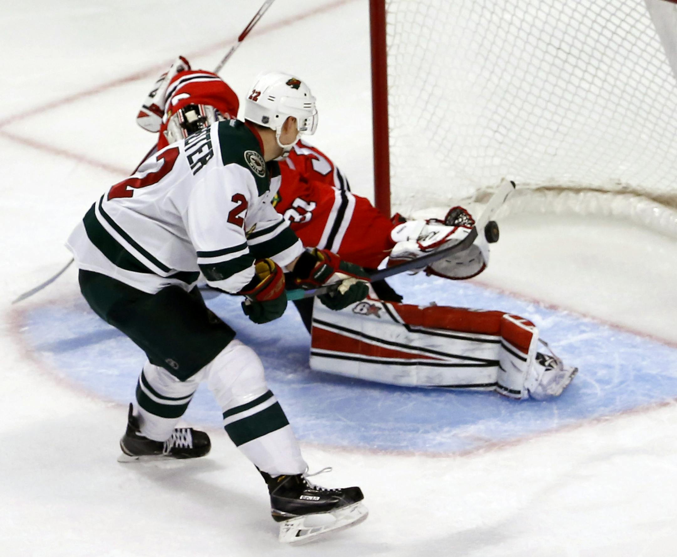 Minnesota Wild right wing Nino Niederreiter scores past Chicago Blackhawks goalie Antti Raanta, on a penalty shot during the third period of an NHL hockey game Tuesday, Dec. 16, 2014, in Chicago. The Blackhawks won 5-3. (AP Photo/Charles Rex Arbogast)