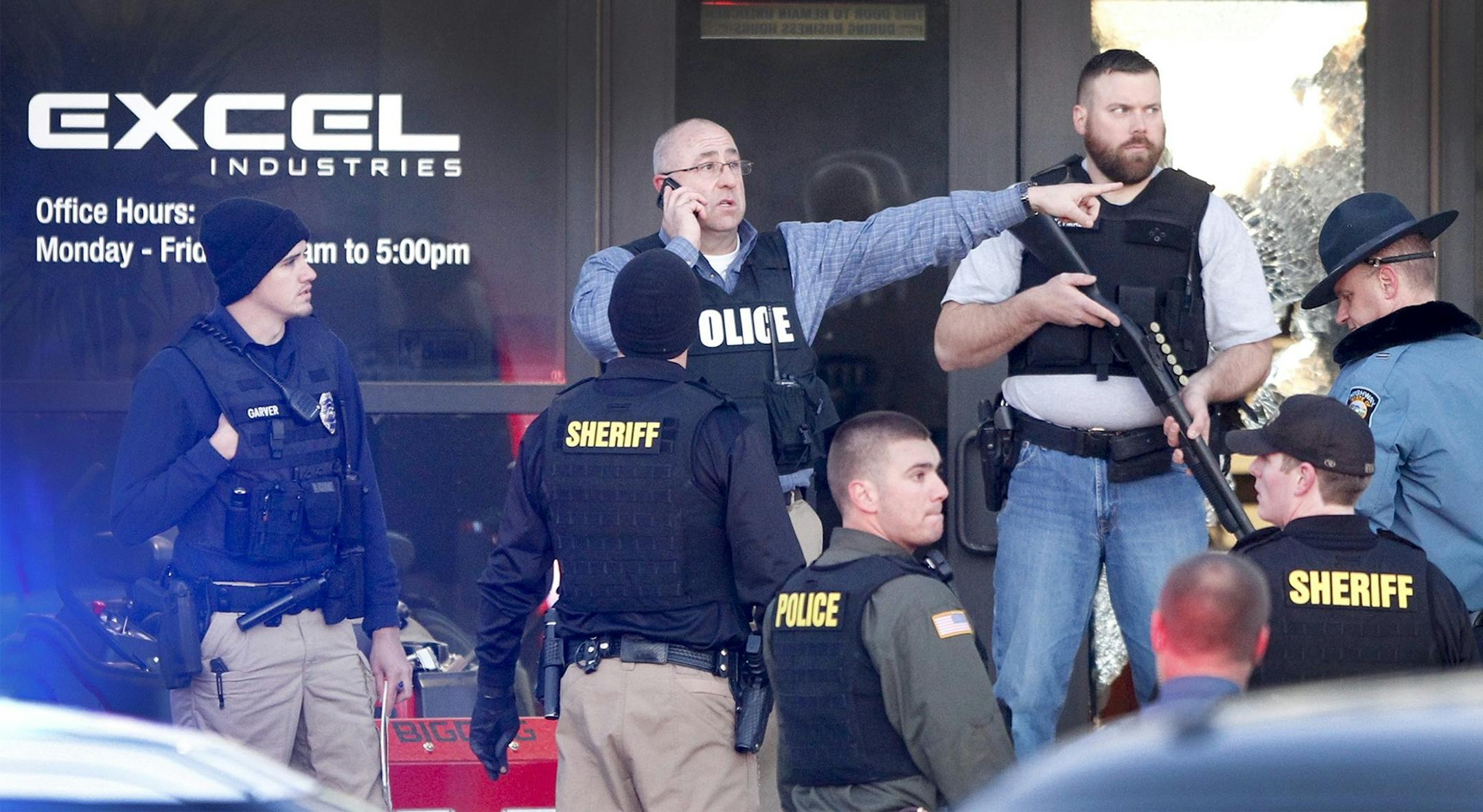 Police guard the front door of Excel Industries in Hesston, Kan., Thursday, Feb. 25, 2016, where a gunman killed an undetermined number of people and injured many more.
