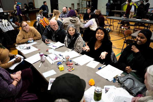 Minneapolis City Council Member Aurin Chowdhury, center, brainstorms community safety ideas for Lake Street and south Minneapolis with her table at a 