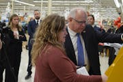 Gov. Tim Walz, right, learned how to get vehicle tabs renewed at a kiosk inside a Cub Foods in Rochester on Tuesday afternoon.
