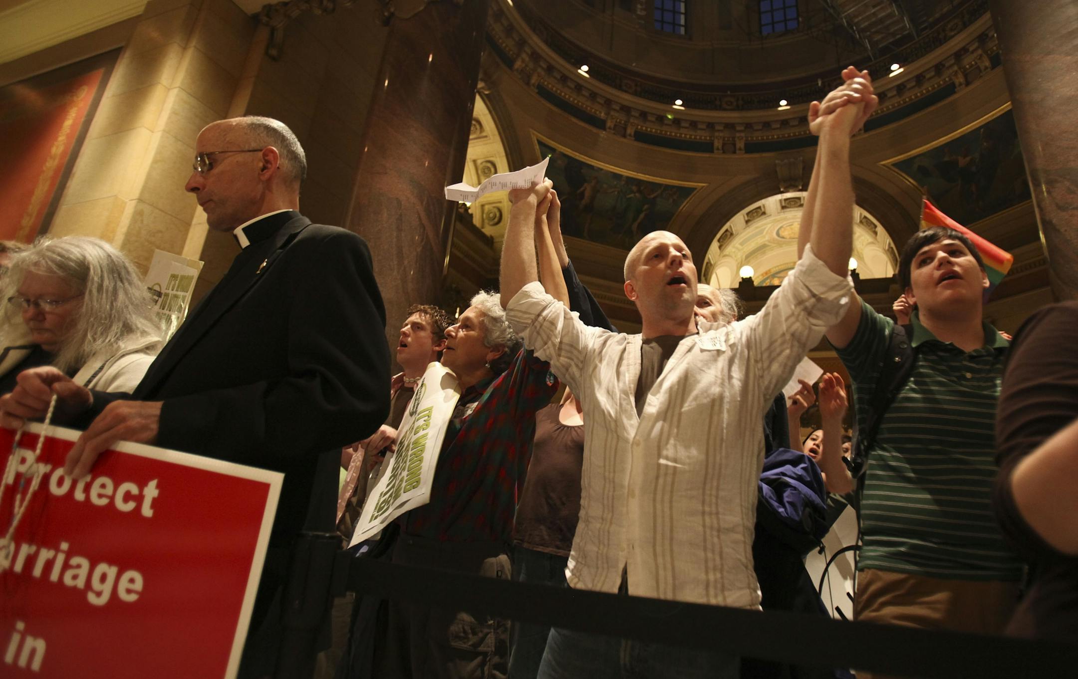 Jim Ivey, of St. Paul, held hands with the people next to him and sang "Amazing Grace" while there was discussion on the House about the marriage amendment debate at the Capitol.