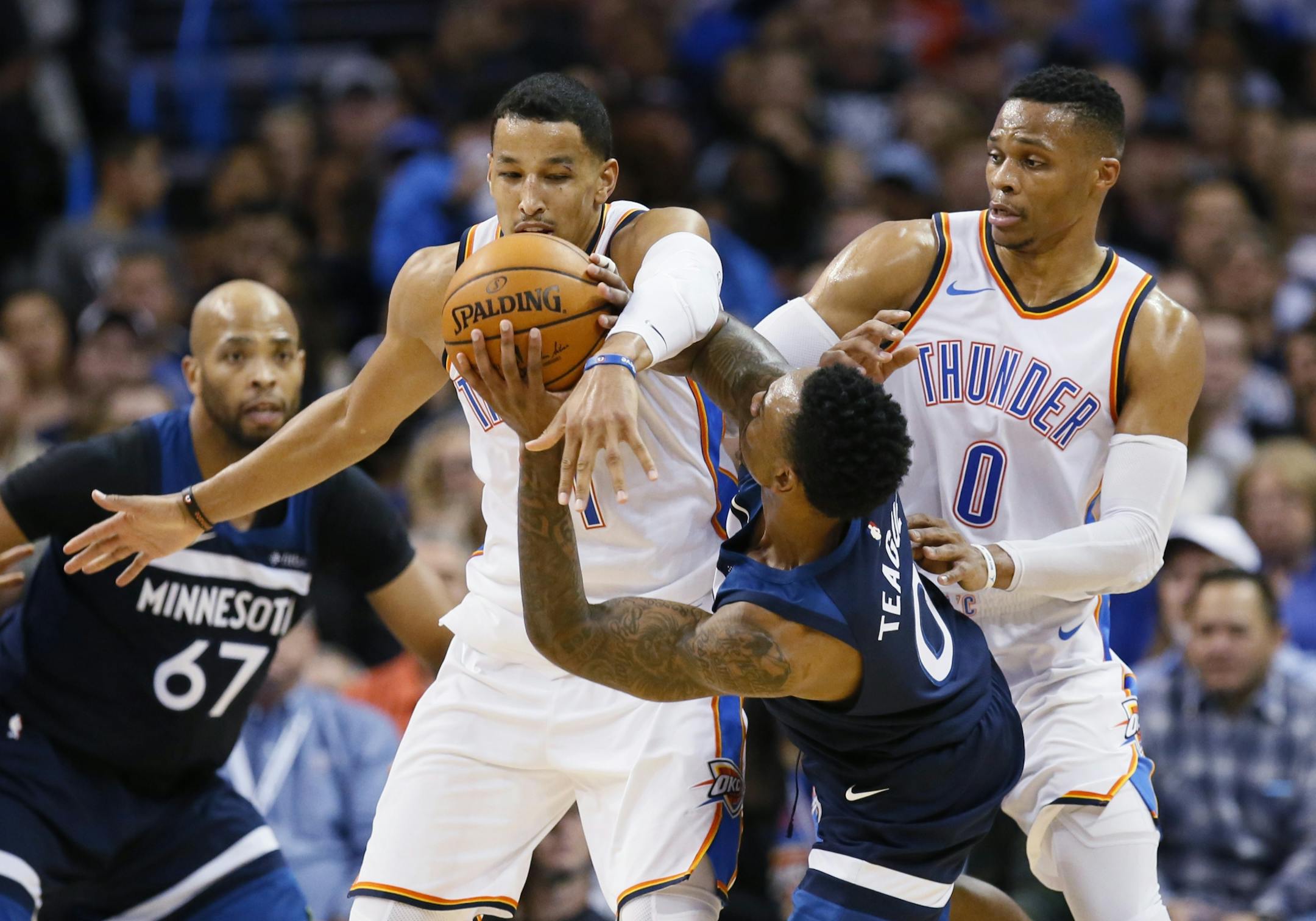 Minnesota Timberwolves guard Jeff Teague (0) is fouled by Oklahoma City Thunder guard Andre Roberson, center, during the second quarter of an NBA basketball game in Oklahoma City, Friday, Dec. 1, 2017. Thunder guard Russell Westbrook is at right.