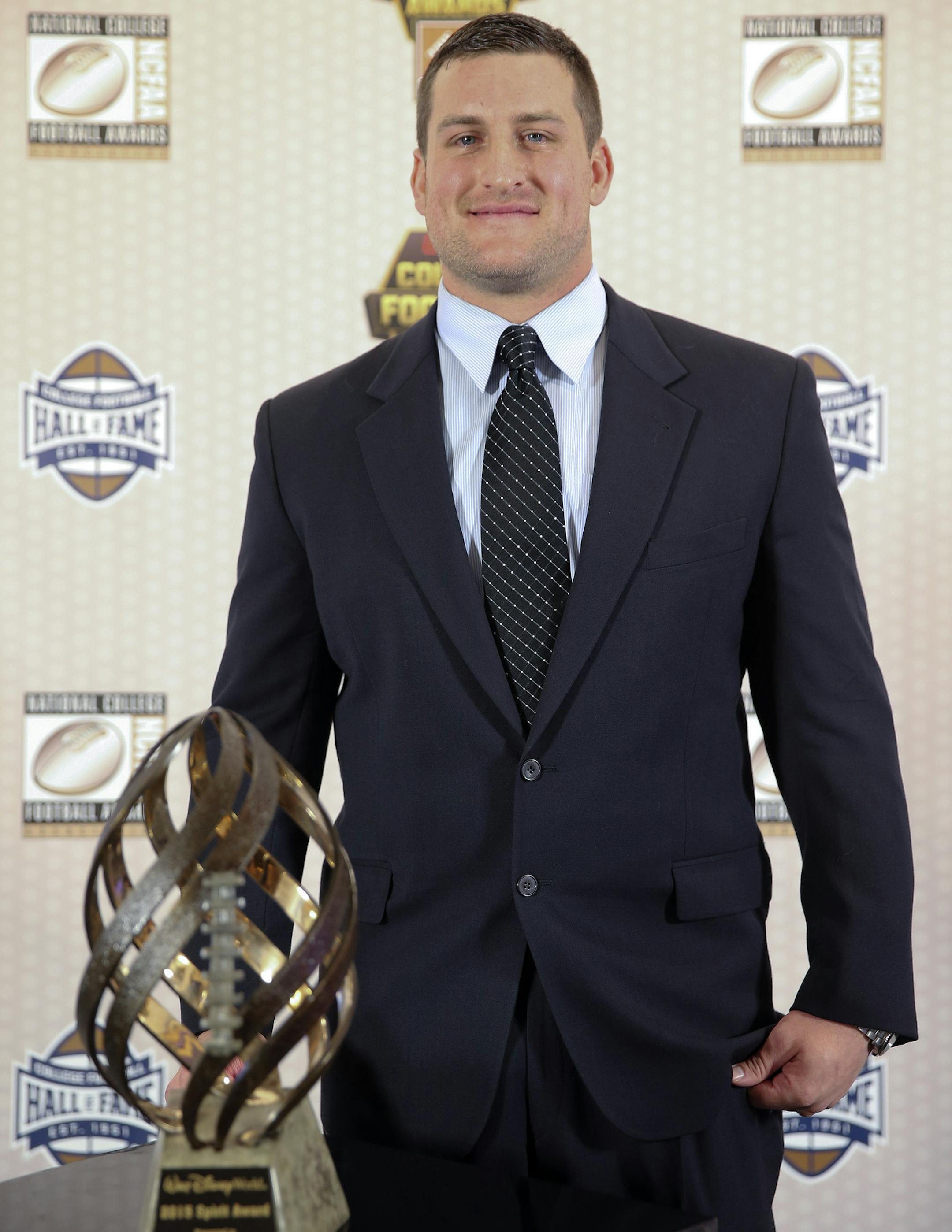 Concorida defensive lineman and U.S. Marine Corps veteran Hank Goff poses with the trophy after winning the Disney Spirit Award at the College Football Hall of Fame, Thursday, Dec. 10, 2015, in Atlanta. (AP Photo/John Bazemore)