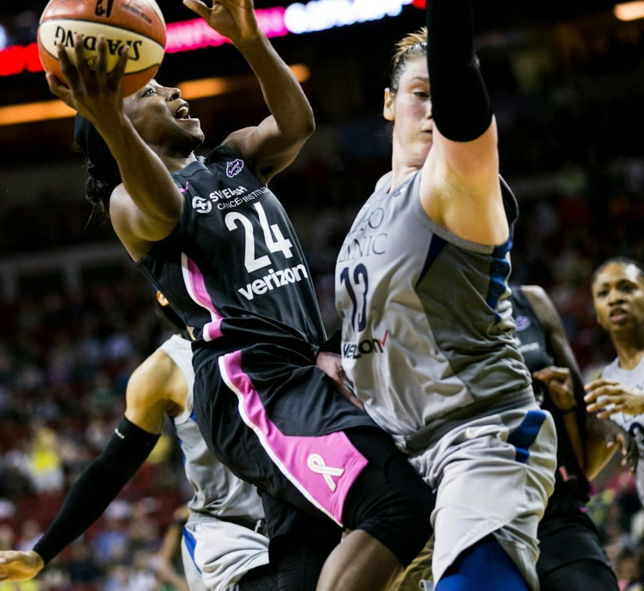 Seattle Storm's Jewell Loyd leaps to take a shot over Minnesota Lynx's Lindsay Whalen during a WNBA basketball game Friday, Aug. 3, 2018, in Seattle.