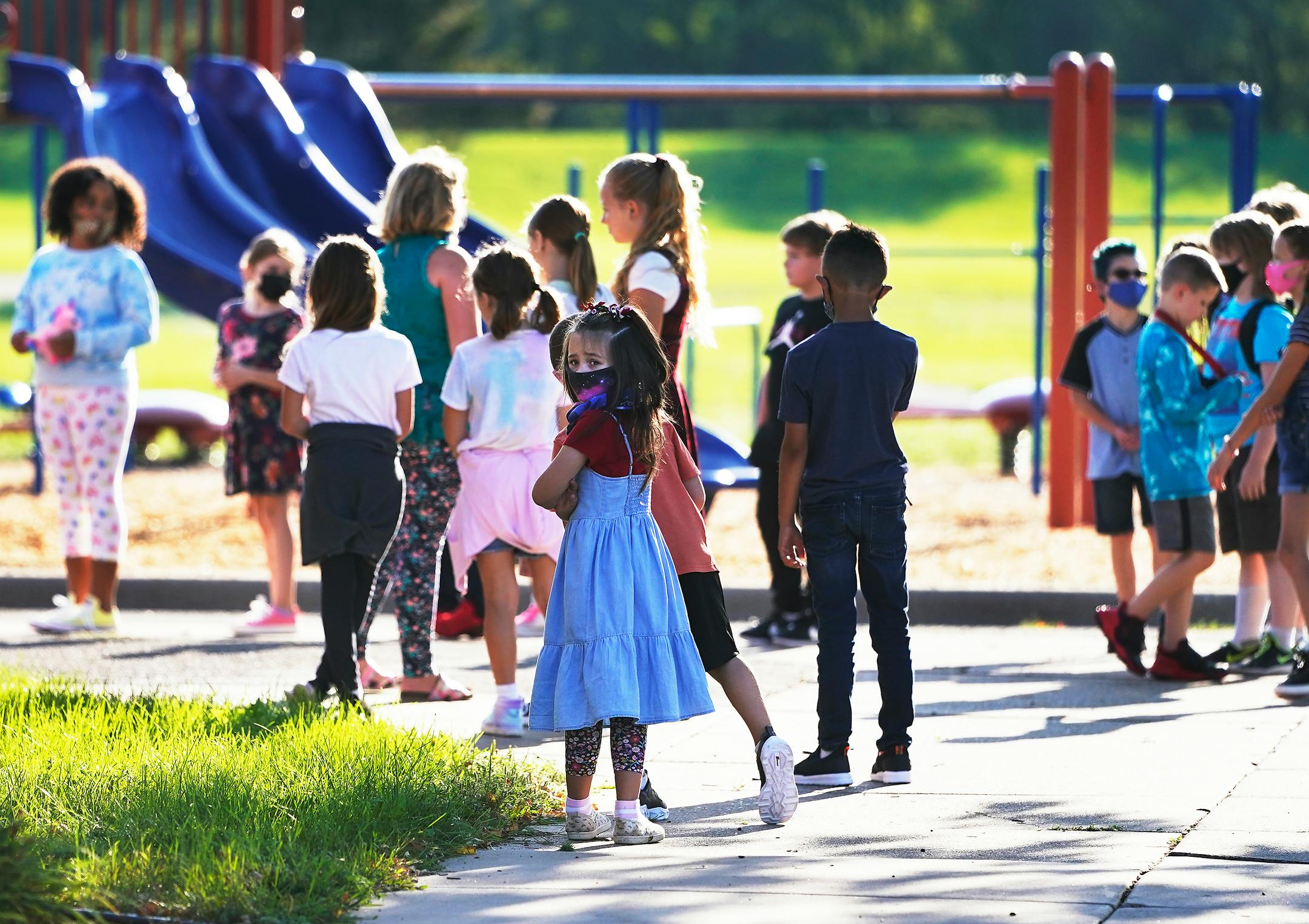 Students in Hoover Elementary School's before school daycare program lined up to head inside the school after playing on the playground before the start of the first day of school Tuesday in Coon Rapids.   ]