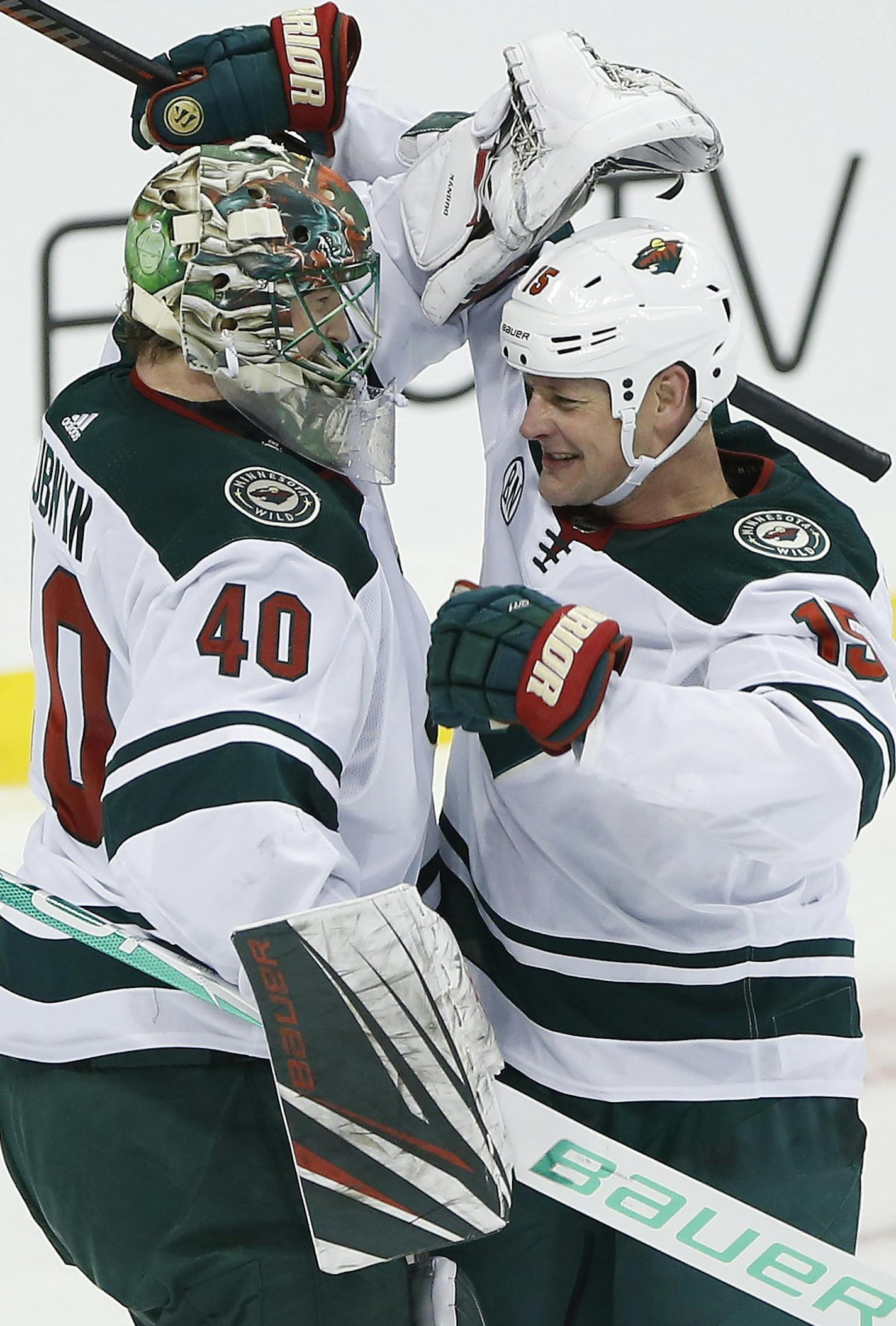 Minnesota Wild's goaltender Devan Dubnyk (40) and Matt Hendricks (15) celebrate a win over the Winnipeg Jets in NHL action in Winnipeg, Manitoba on Saturday, Dec. 29, 2018. (John Woods/The Canadian Press via AP)