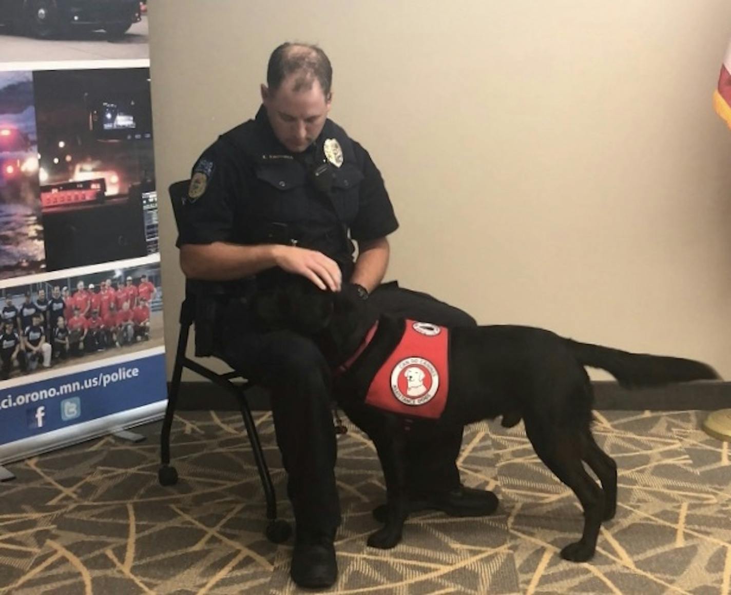 Xerxes, a canine officer for the Orono Police Departments, "visits" Officer Kyle Kirschner by laying his head in his lap. The dog would use this technique to comfort individuals when police respond to a crisis call.