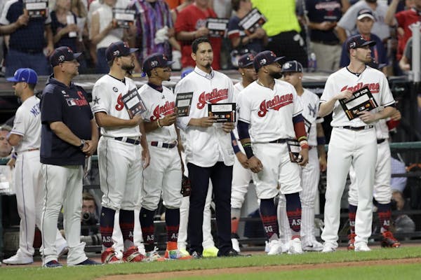 Cleveland Indians pitcher Carlos Carrasco, stands with Indians teammates during the fifth inning of the MLB baseball All-Star Game, Tuesday, July 9, 2