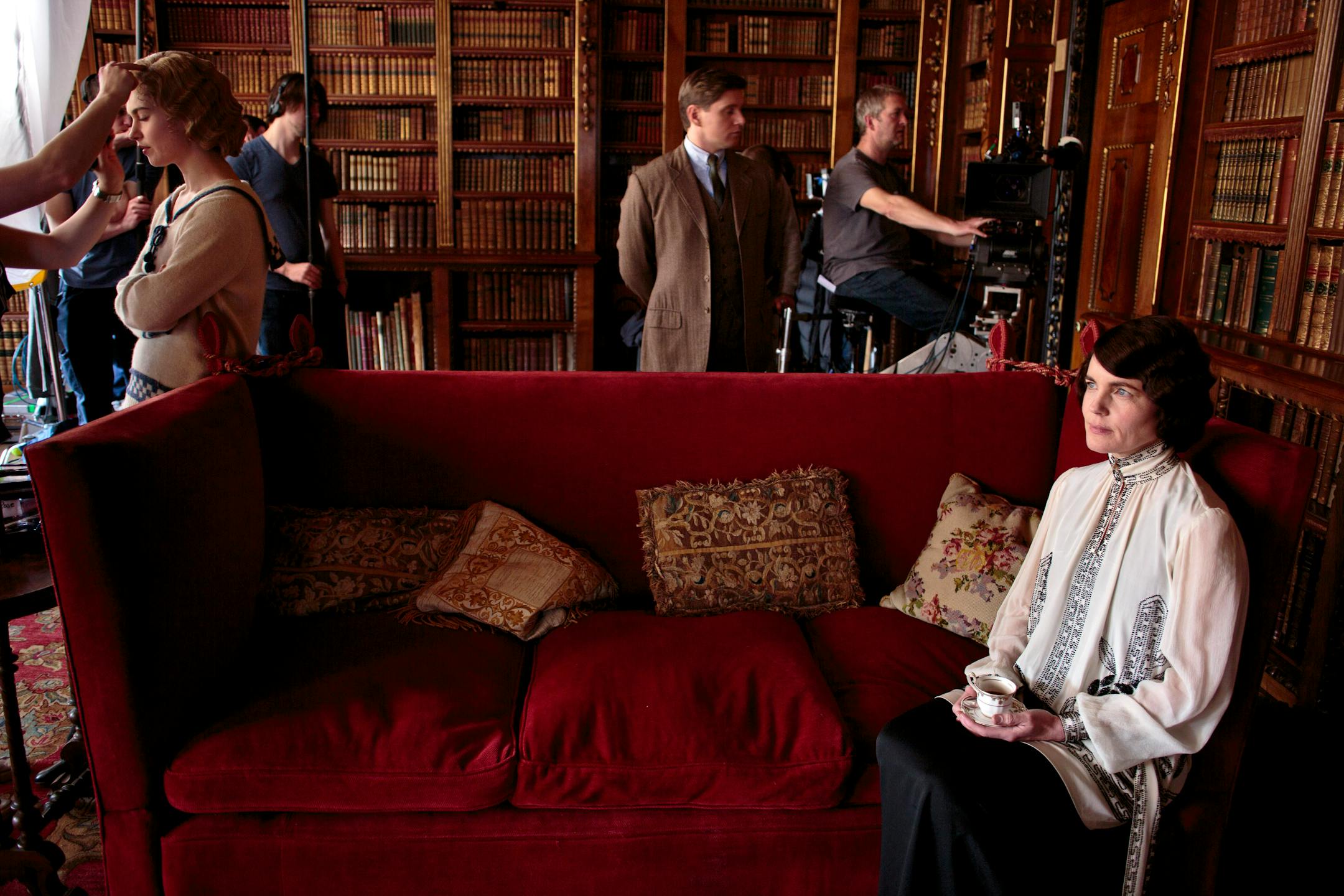 Actors Lily James, left, Allen Leech, center, and Elizabeth McGovern, seated, prepare for a scene on set of "Downton Abbey" at Highclere Castle in Hampshire, England, April 23, 2013. The Crawley family struggle to recover from a tragic death in the fourth season of the hit British drama, making a long-awaited return to PBS in January 2014. (Nick Briggs/The New York Times) — PHOTO MOVED IN ADVANCE AND NOT FOR USE - ONLINE OR IN PRINT - BEFORE JAN. 05, 2014.