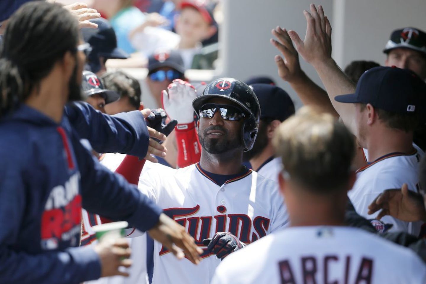 Minnesota Twins' Eduardo Nunez, center, is congratulated in the dugout after scoring on a sacrifice fly out by Danny Santana in the third inning of a spring training baseball game against the Tampa Bay Rays on Wednesday, March 23, 2016, in Fort Myers, Fla.