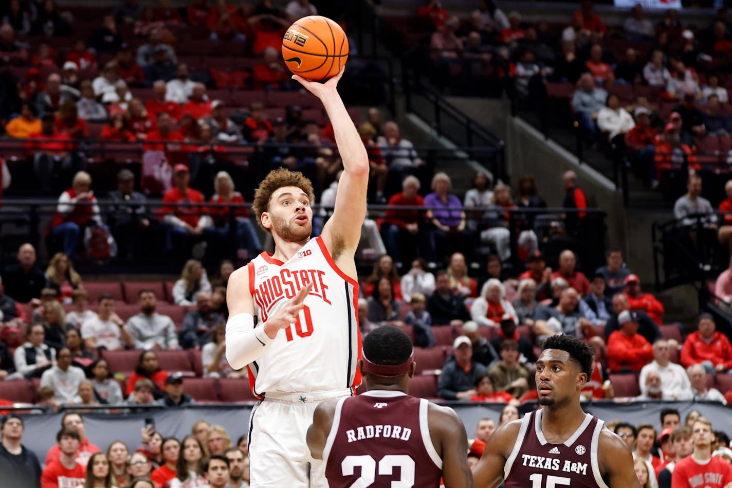 Ohio State forward Jamison Battle, left, shoots over Texas A&amp;M guard Tyrece Radford, center, and forward Henry Coleman during an NCAA college basketball game in Columbus, Ohio, Friday, Nov. 10, 2023. Texas A&amp;M won 73-66. (AP Photo/Paul Vernon)