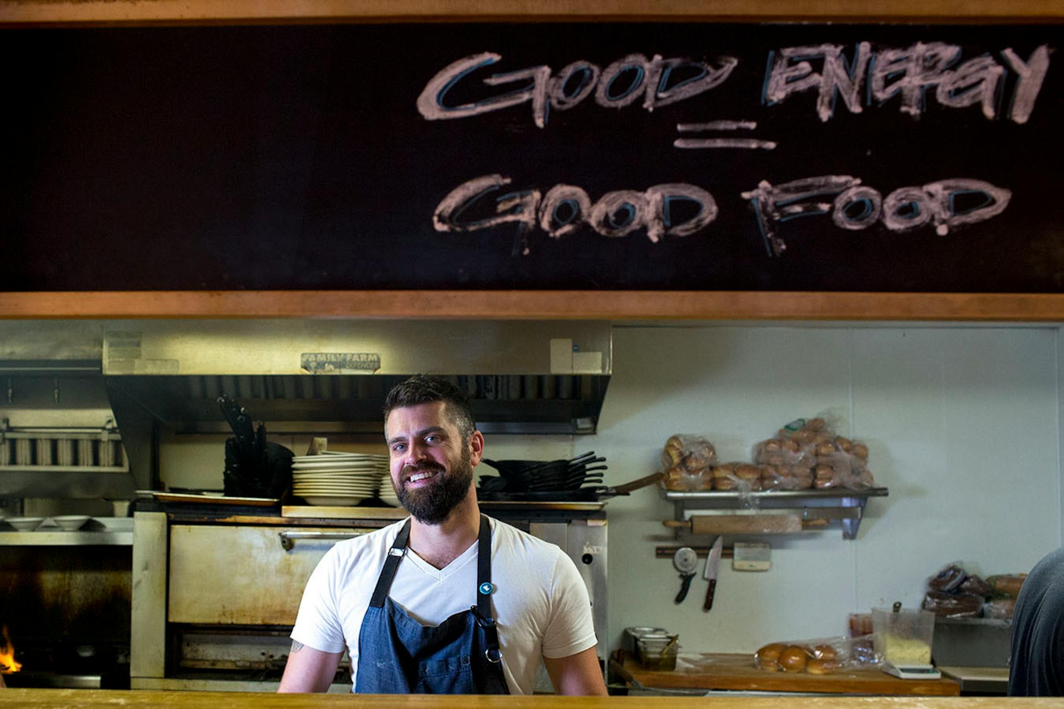 Driftless Cafe chef Luke Zahm poses for a portrait in the kitchen behind the chalkboard displayed to the customers. 85% of the food budget is spent on farms within a 30 mile radius, according to Zahm. ] COURTNEY PEDROZA • courtney.pedroza@startribune.com June 22-24, 2017; Wisconsin restaurants, cafes, bars, bakeries and breweries; Dining along the Mississippi River.