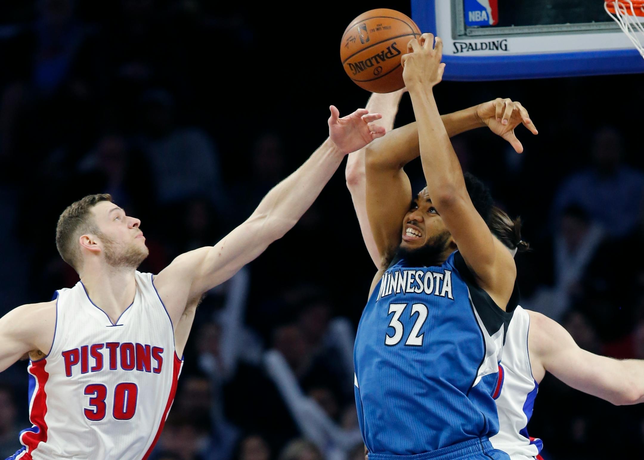 Minnesota Timberwolves center Karl-Anthony Towns (32) and Detroit Pistons forward Jon Leuer (30) reach for the rebound during the second half of an NBA basketball game, Friday, Feb. 3, 2017, in Auburn Hills, Mich. (AP Photo/Carlos Osorio)