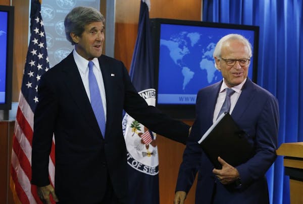 Secretary of State John Kerry stands with former U.S. Ambassador to Israel Martin Indyk at the State Department as he announces that Indyk will shephe