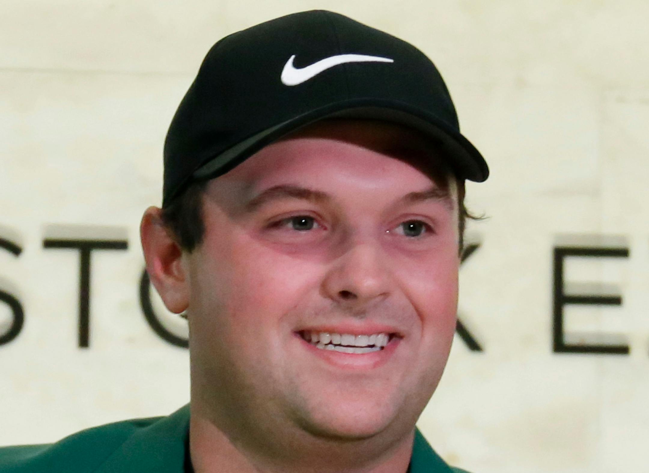Masters golf champion Patrick Reed holds a pin flag he autographed during his visit to the trading floor of the New York Stock Exchange, Monday, April 9, 2018. (AP Photo/Richard Drew)