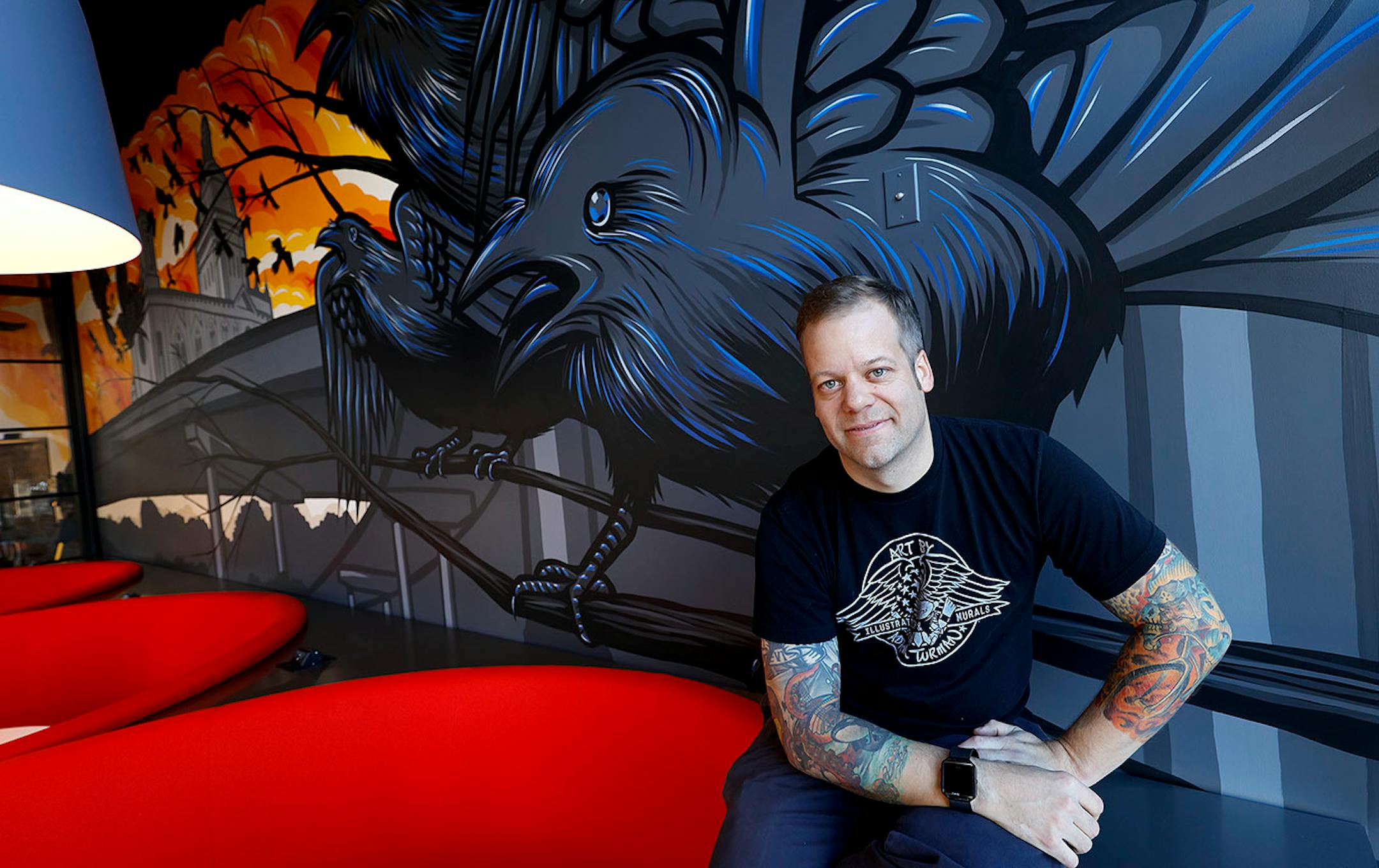 The everywhere artist, Adam Turman, His clean, dynamic murals crawl up the sides of breweries, in elementary schools, the lobby of downtown Minneapolis' hip, new hotel. He boasts T-shirts and pint glasses and posters. He's even created a jigsaw puzzle. Here, Adam Turman in front of his owl mural. The mural is located at the A-Mill Artist Lofts, Minneapolis.