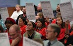Members of the St. Paul Federation of Teachers wore their signature red shirts and held signs during a public comment period in October 2017.