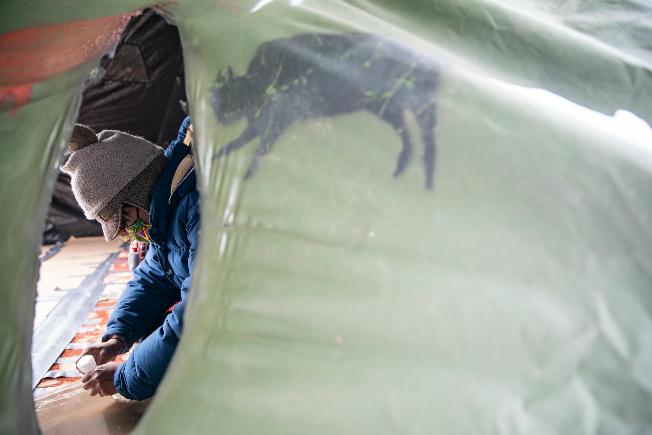 Alex Golden-Wolf walked worked on repairing a tent inside Camp Migizi. Migizi is a small encampment of mostly indigenous water and land protectors located right beside the Enbridge Line 3 construction site on the Fond Du Lac Native American reservation in Cloquet.