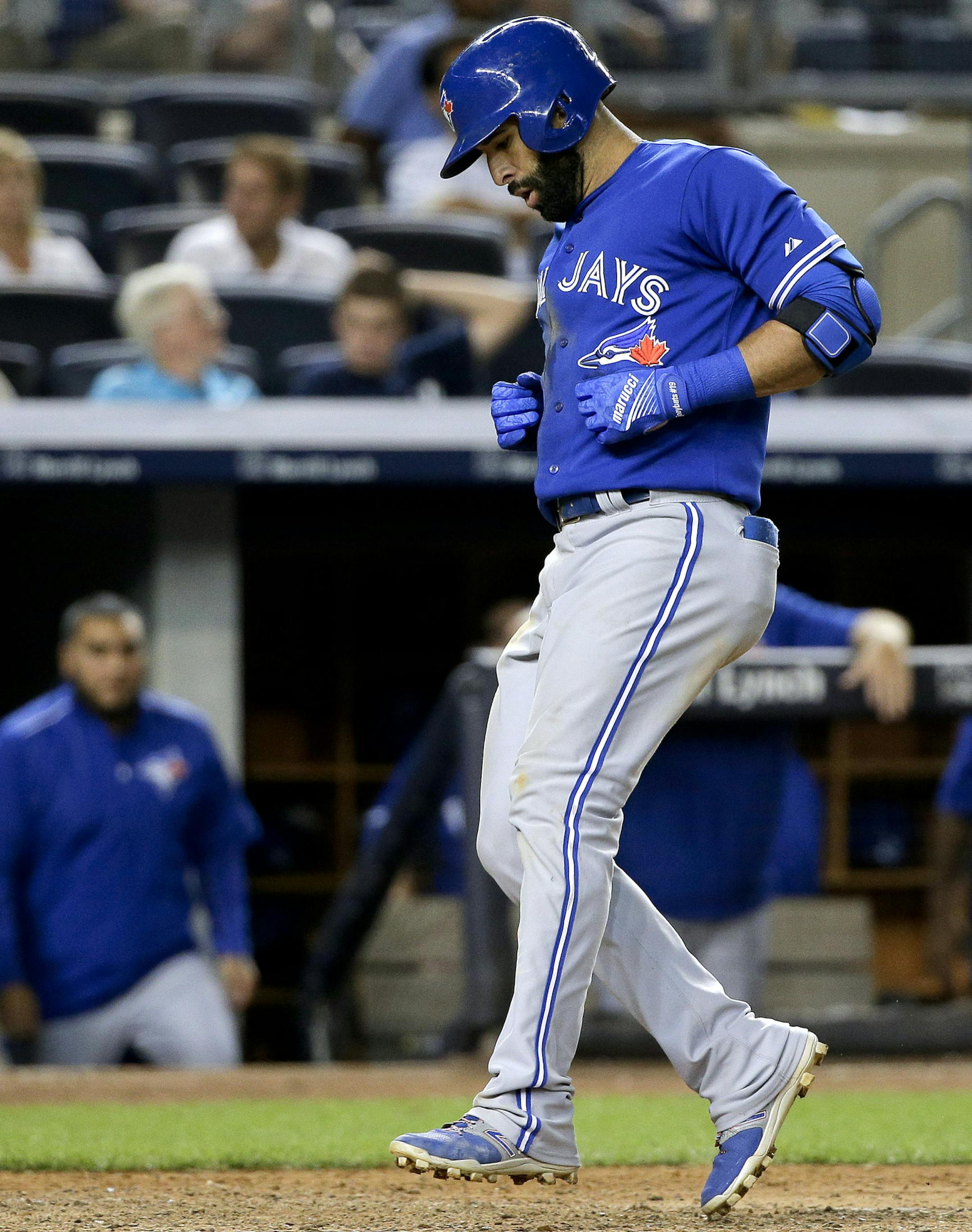 Toronto Blue Jays' Jose Bautista crosses home plate after hitting a solo home run against the New York Yankees during the 10th inning of a baseball game, Friday, Aug. 7, 2015, in New York. The Blue Jays won 2-1 in 10 innings. (AP Photo/Julie Jacobson)