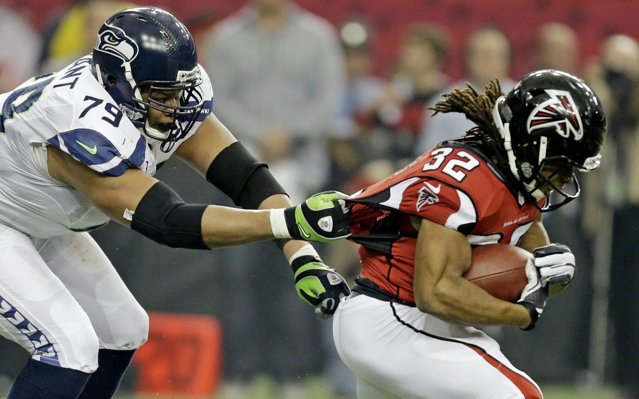 Seattle Seahawks' Red Bryant (79) tries to stop Atlanta Falcons' Jacquizz Rodgers (32).