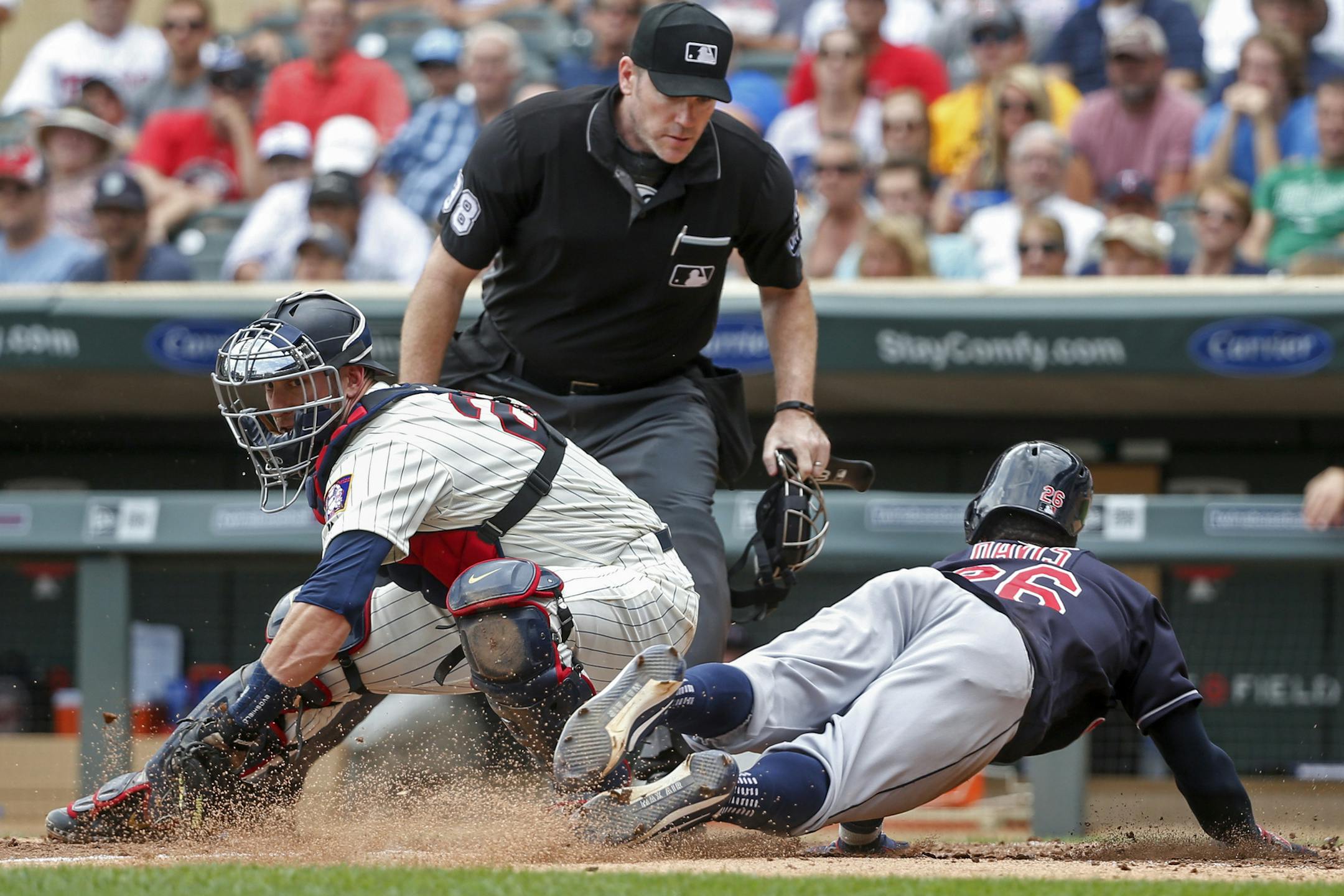 Cleveland Indians Rajai Davis, right, slides ahead of the play by Minnesota Twins catcher Mitch Garver to steal home as umpire Chris Conroy watches in the sixth inning of a baseball game Wednesday, Aug. 1, 2018, in Minneapolis. (AP Photo/Bruce Kluckhohn)