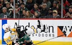 Minnesota Wild's Eric Staal (12) and Pittsburgh Penguins' Riley Sheahan (15) fall while going after the puck during the second period of an NHL hockey