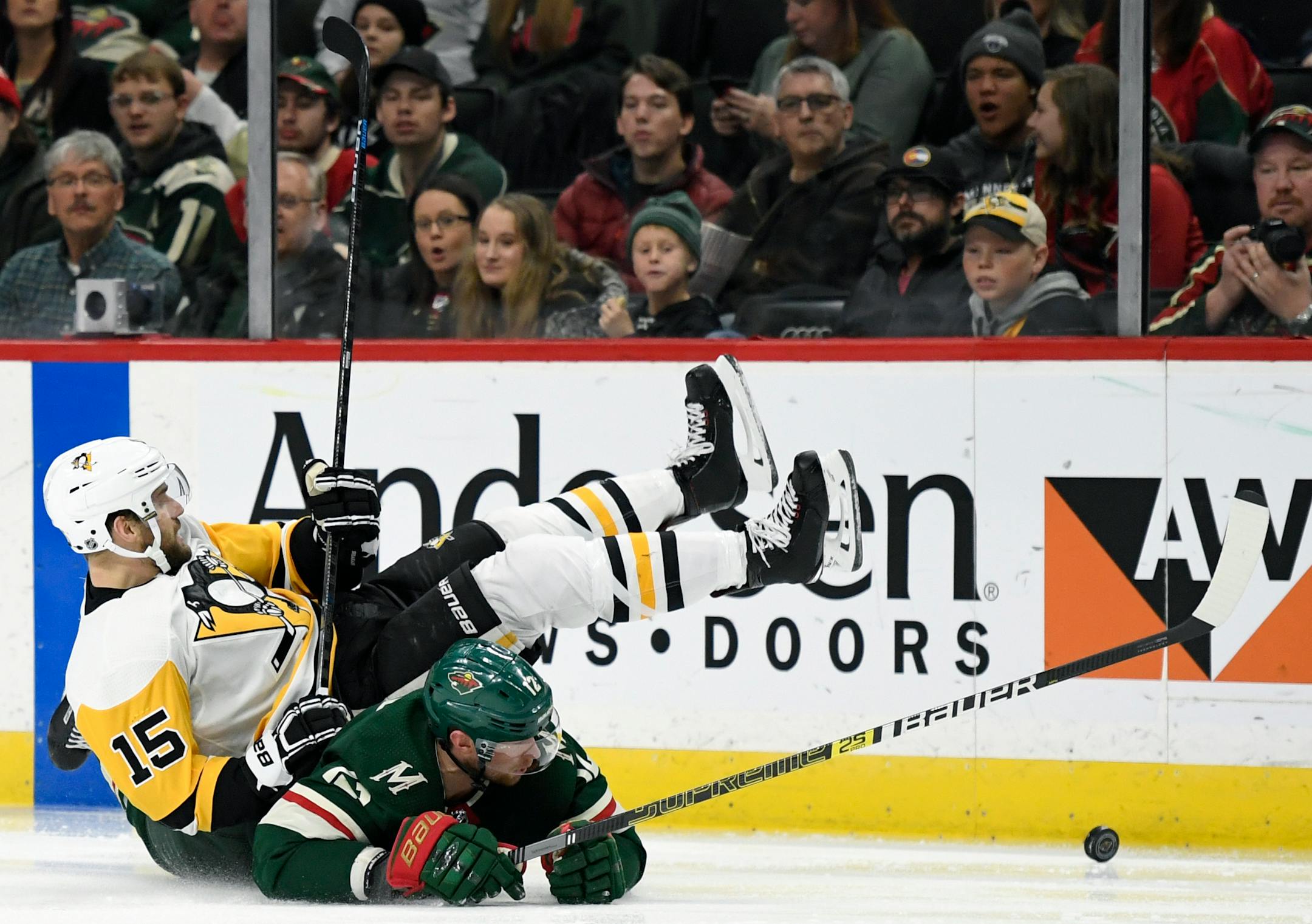Minnesota Wild's Eric Staal (12) and Pittsburgh Penguins' Riley Sheahan (15) fall while going after the puck during the second period of an NHL hockey game Monday, Dec. 31, 2018, in St. Paul, Minn. (AP Photo/Hannah Foslien)