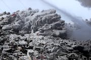 Ice covered junker cars are seen as firefighters on Wednesday morning remained on the scene of a fire that has been burning for more than 24 hours at 