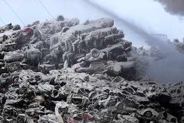 Ice covered junker cars are seen as firefighters on Wednesday morning remained on the scene of a fire that has been burning for more than 24 hours at 