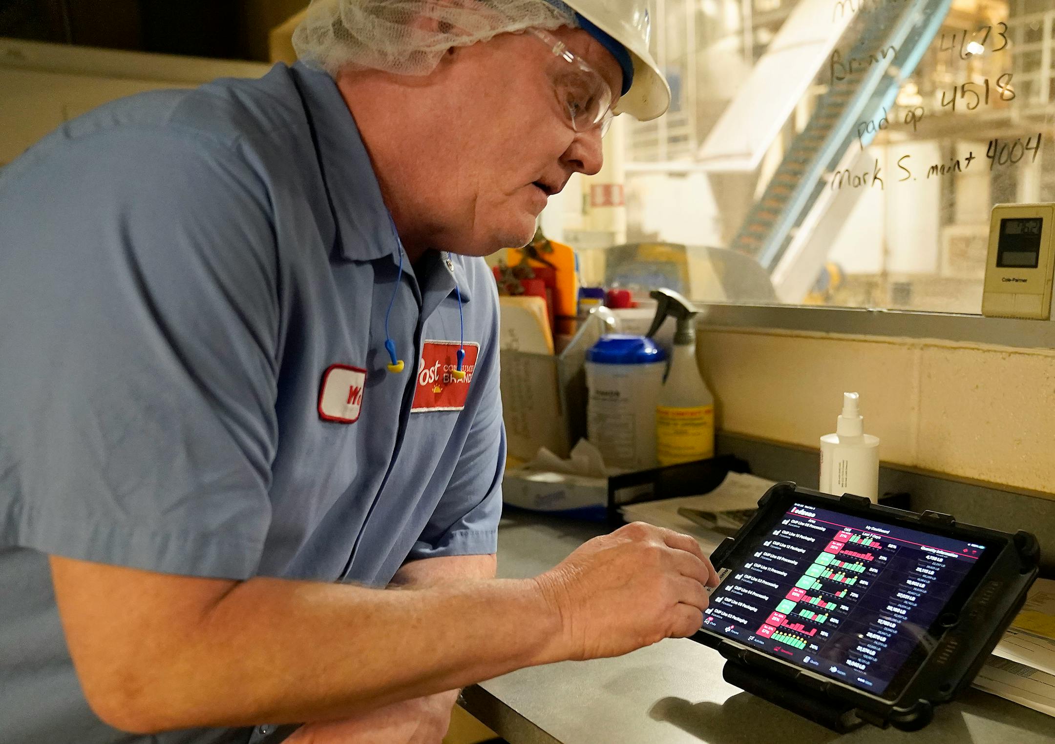 Wade Armstrong, a processing specialist, uses a computer pad to monitor progress of a cereal batch.