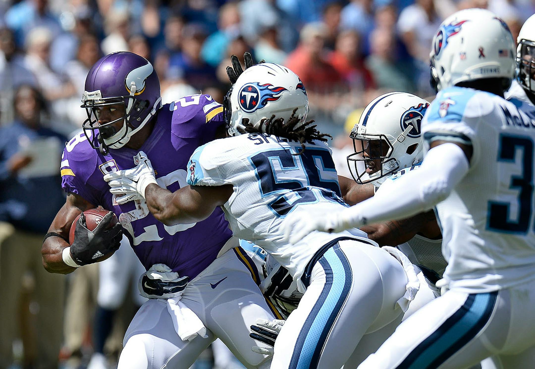 Minnesota Vikings running back Adrian Peterson tries to get past Titans defenders including Sean Spence (55) in the first half last week.
