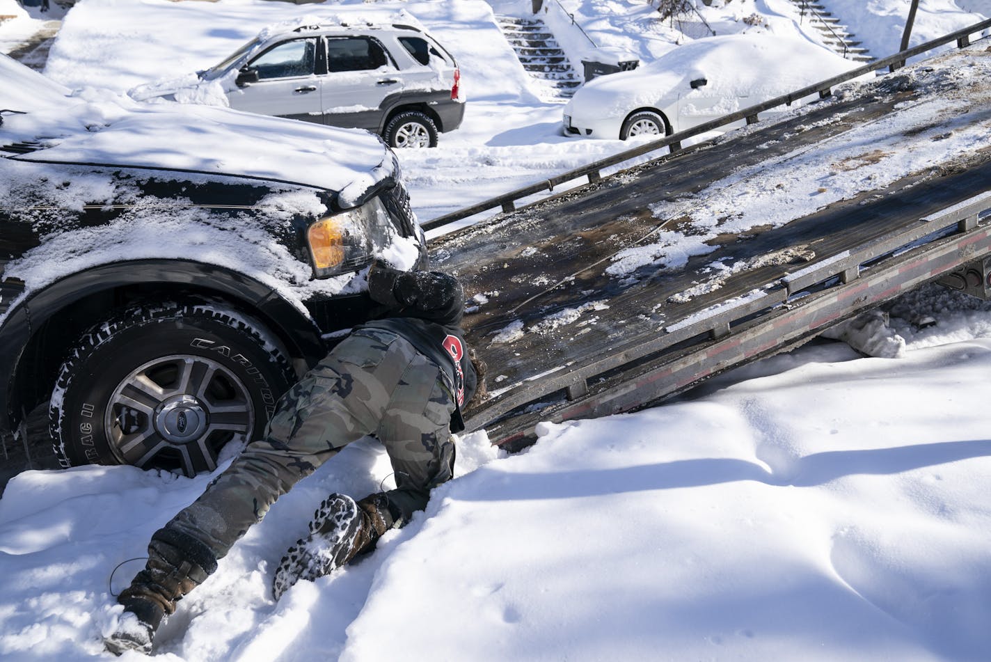 Kerry Brendmoen of Corky's Towing hitched a vehicle to his tow flatbed that was parked on wrong snow emergency side of Beard Avenue South in Minneapolis, Minn., on Friday, February 8, 2019. The snow plow was waiting for that side of the street to be cleared so it could finish plowing the road.