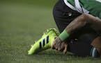 Sporting's Raphinha hold his right ankle after sustaining an injury during the Europa League round of 32, first leg, soccer match between Sporting CP 