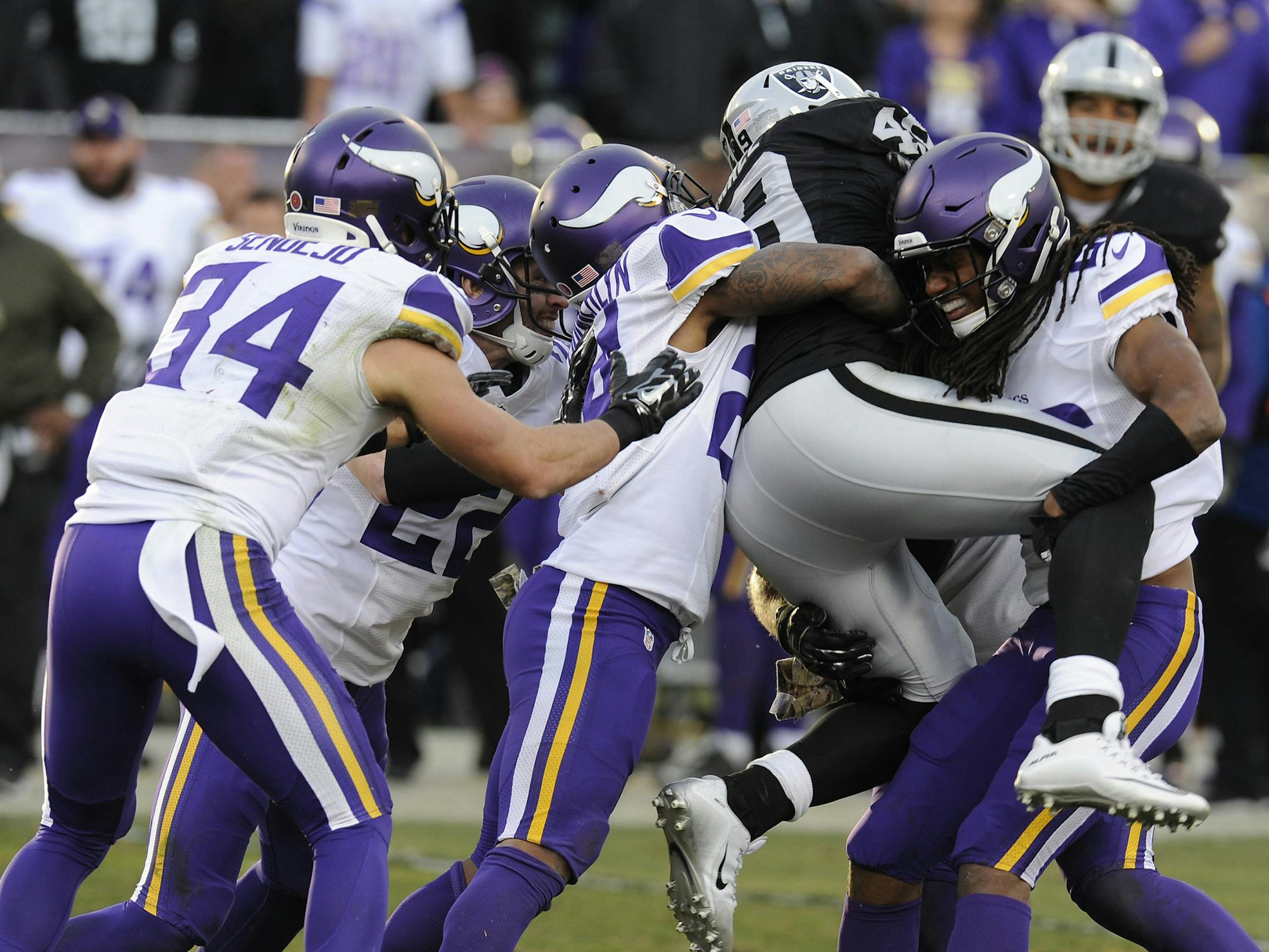 Minnesota Vikings' Trae Waynes (26) lifts up Oakland Raiders' Jamize Olawale (49) as they tackle him during the fourth quarter on Sunday, Nov. 15, 2015, at O.co Coliseum in Oakland, Calif. (Jose Carlos Fajardo/Bay Area News Group/TNS)