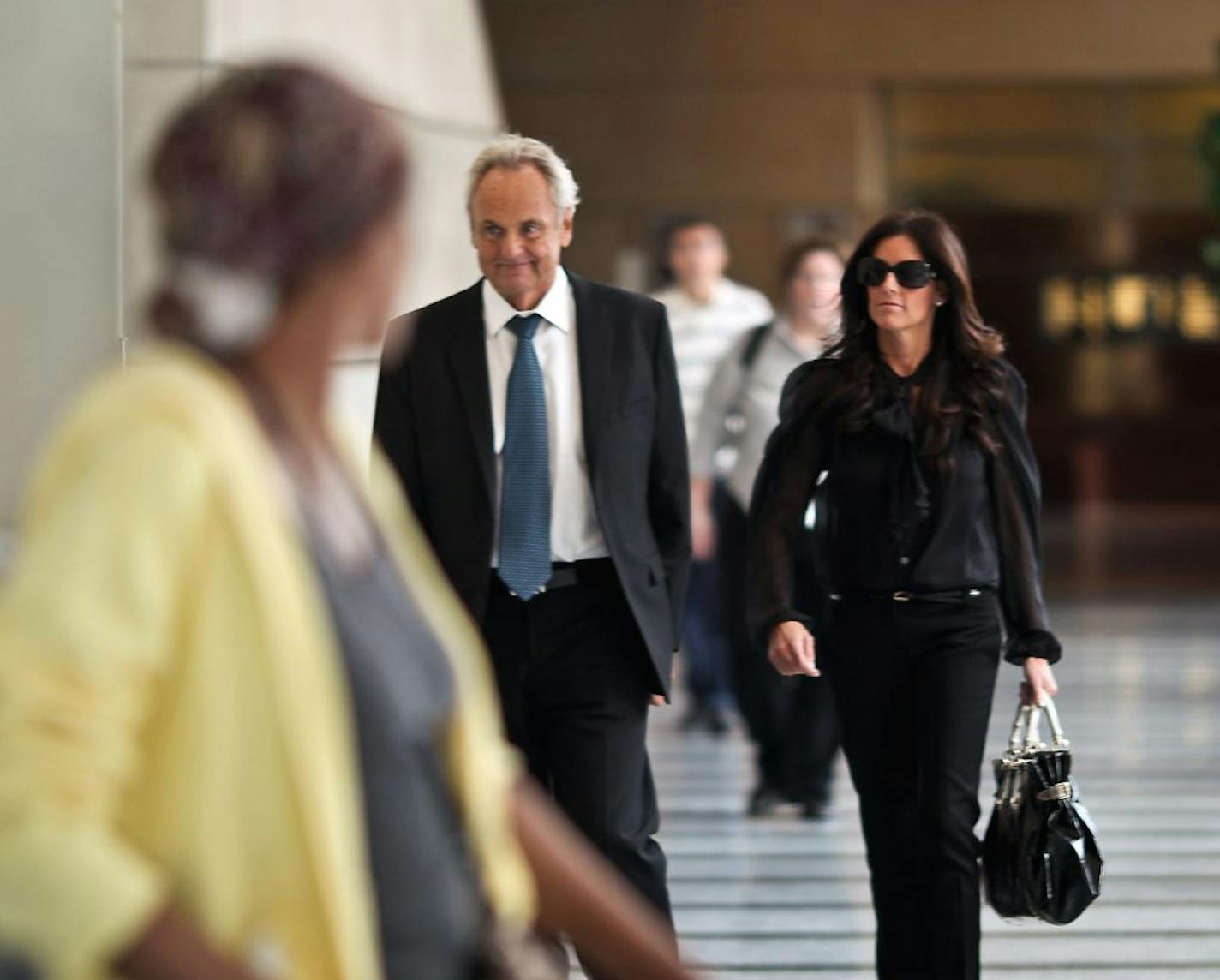 Denny Hecker walked with his girlfriend, Christi Rowan, as he left federal court in Minneapolis Tuesday afternoon after pleading guilty to various fraud charges.