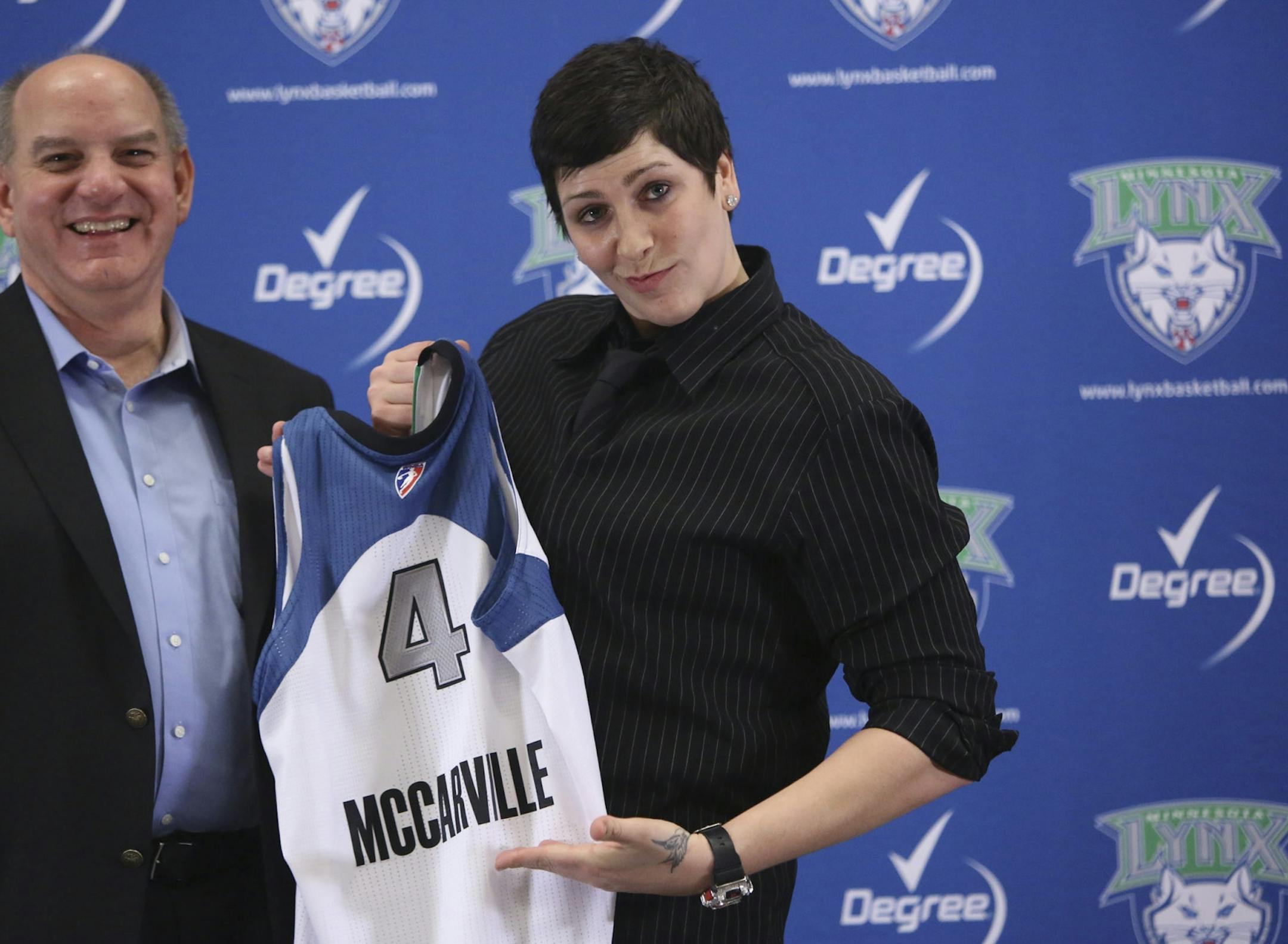 Executive Vice President Roger Griffith and former Gopher center Janel McCarville held up her new Lynx jersey.
