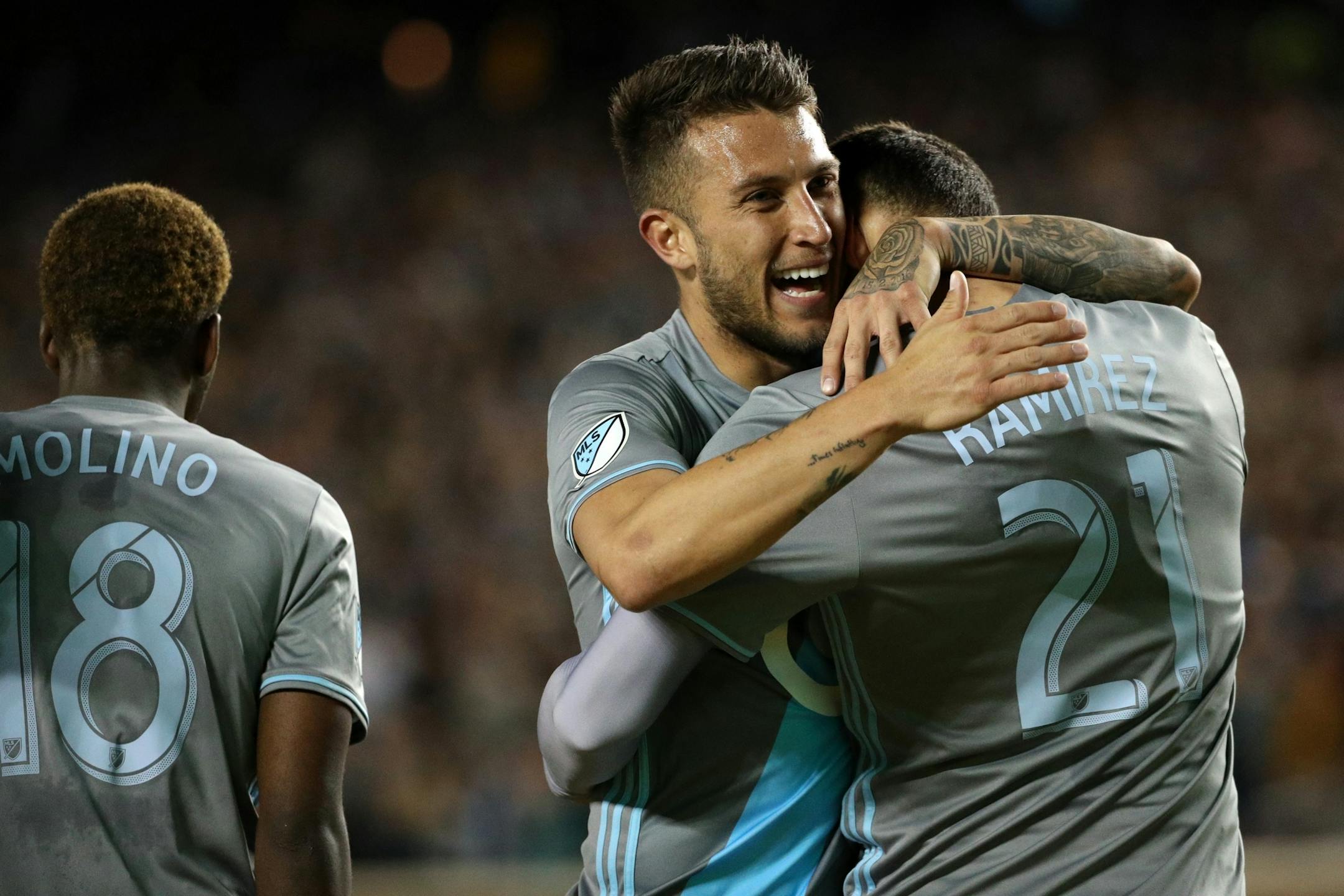Minnesota United forward Christian Ramirez (21) gets congratulated by Minnesota United defender Francisco Calvo (5) after he took the ball from Real Salt Lake goalkeeper Nick Rimando (18) to score in the second half.