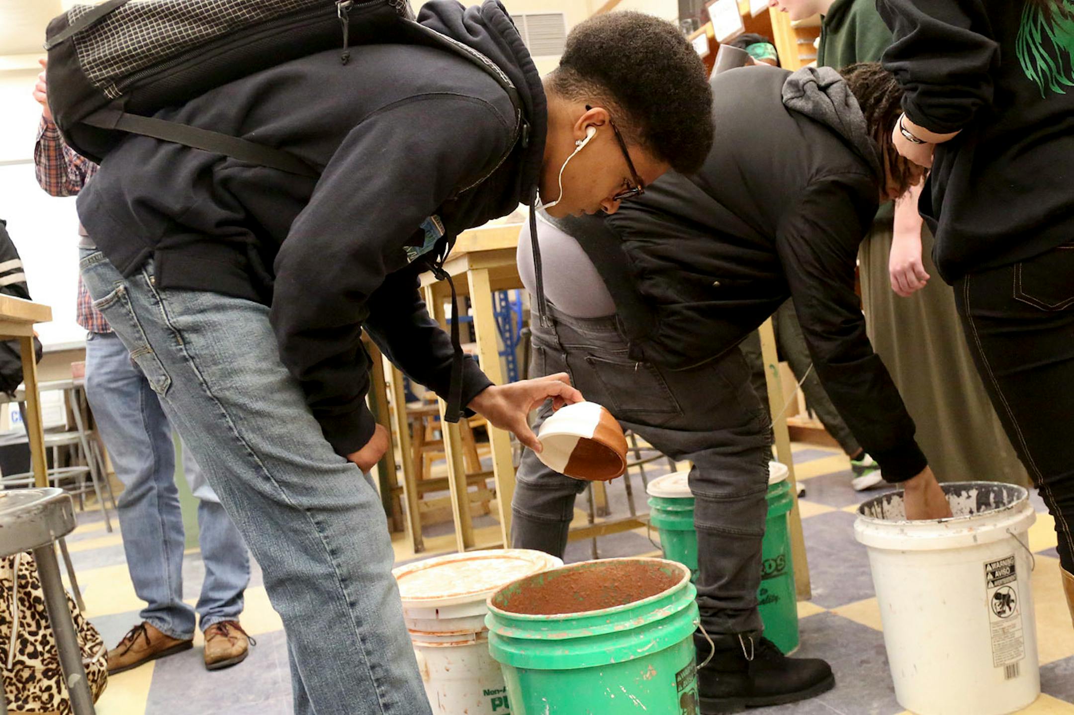 Edison High 10th grader Robert Hampton glazes a bowl for the Empty Bowls fundraiser at Edison High School Thursday, April 13, 2017, in Minneapolis, MN. "It's a good thing helping out our community," Hampton said, adding "it's a good way to keep people busy."