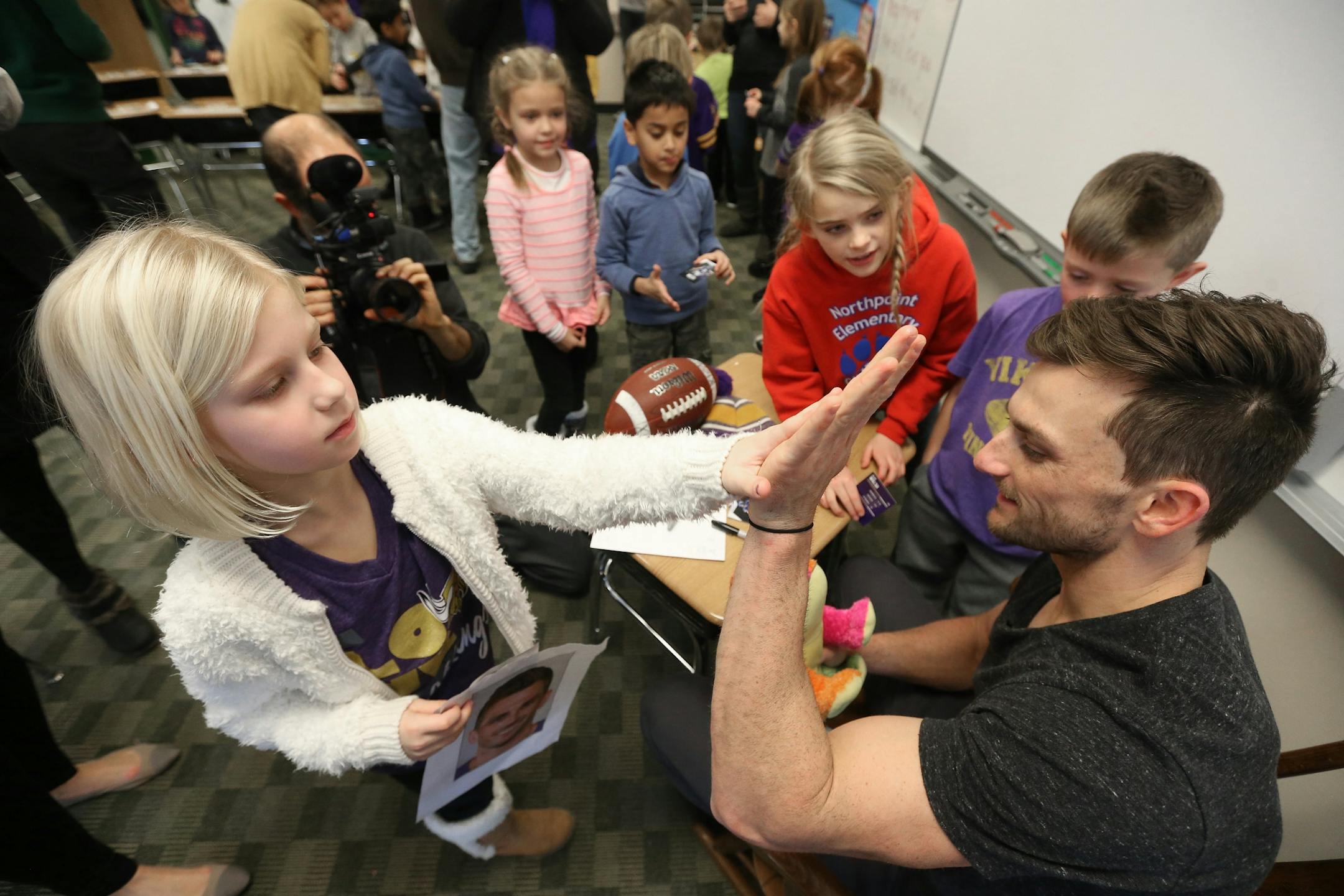 Kyleigh Duerr left gave a high five to Minnesota Vikings kicker Blair Walsh after giving him a stuffed animal. Walsh thanked first graders at Northpoint Elementary School for writing letters of encouragement to him after he missed a 27-yard field goal in last Sunday's game with Seattle Thursday January 14, 2016 in Blaine, MN.