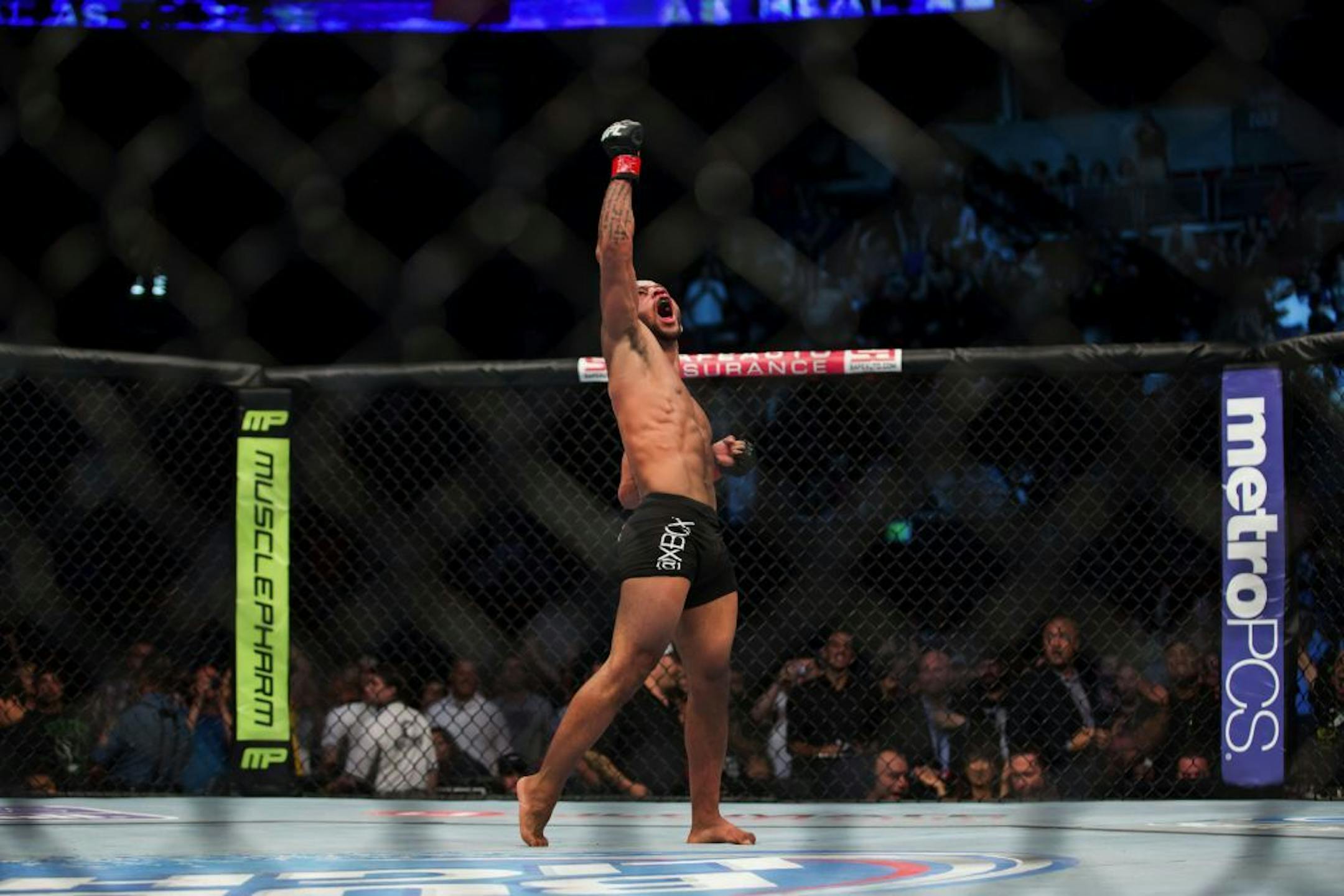 UFC flyweight champion Demetrious Johnson celebrates his victory over John Moraga in Seattle, on Saturday, July 27, 2013. Johnson used an armbar in the fifth round to defend his title