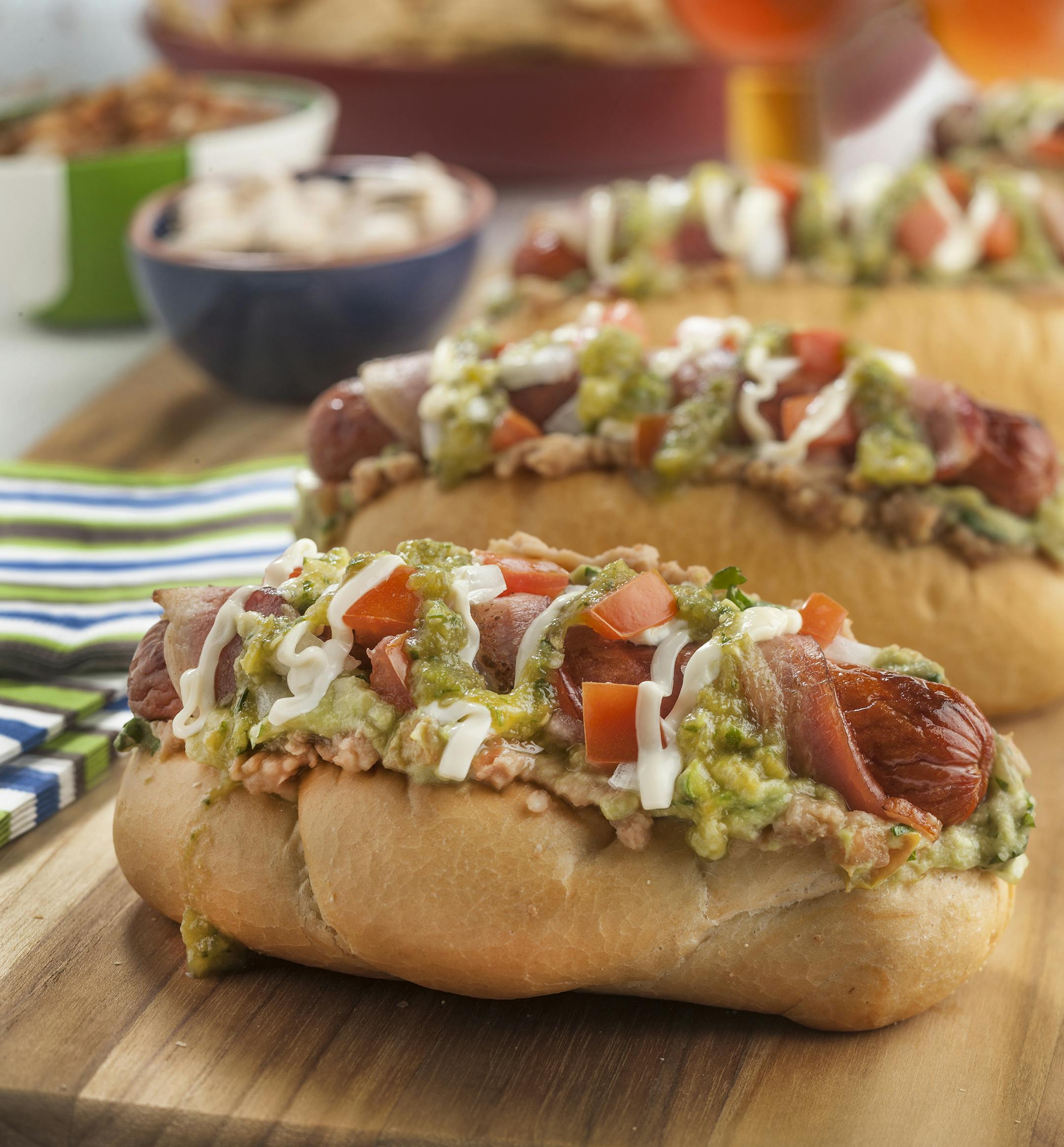 The Sonoran hot dog has a complex architecture, built with bacon, guacamole, refried beans, cheese, onion, tomato, salsa and mayo. (Bill Hogan/Chicago Tribune/TNS) ORG XMIT: 1162955