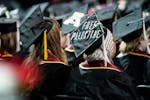 A student sits with her cap decorated to read "Free Palestine" while attending the University of Minnesota's College of Liberal Arts graduation ceremo