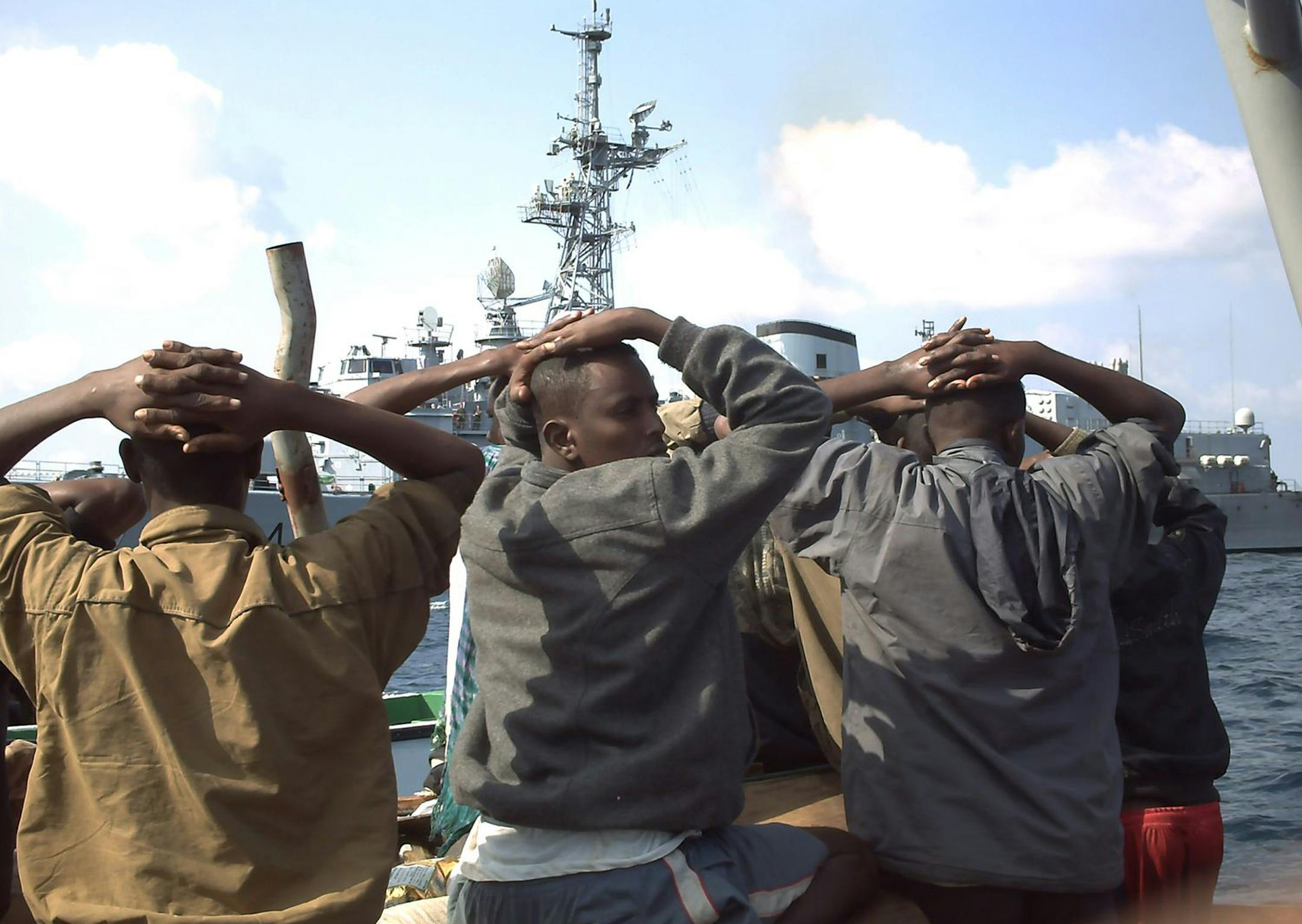 FILE - This file photo taken Sunday, Jan. 4, 2009 originally provided by French Defense Ministry, shows suspected pirates arrested by marine commandos of the French navy in the Gulf of Aden, off Somalia coasts. French government officials say the Jean de Vienne,background, intercepted and captured 19 pirates as they tried to take over two cargo ships. Many captured Somali pirates once were freed because nations feared the complications of putting them on trial. But the world is now grappling wit
