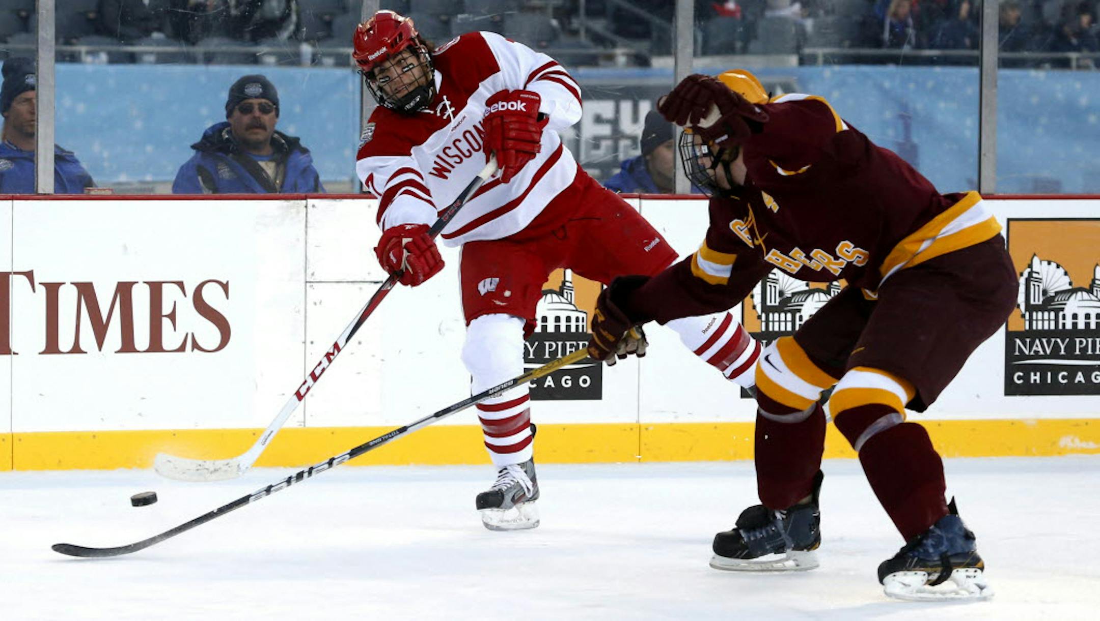 Wisconsin forward Tyler Barnes, left, shot past Gophers defenseman Seth Helgeson.