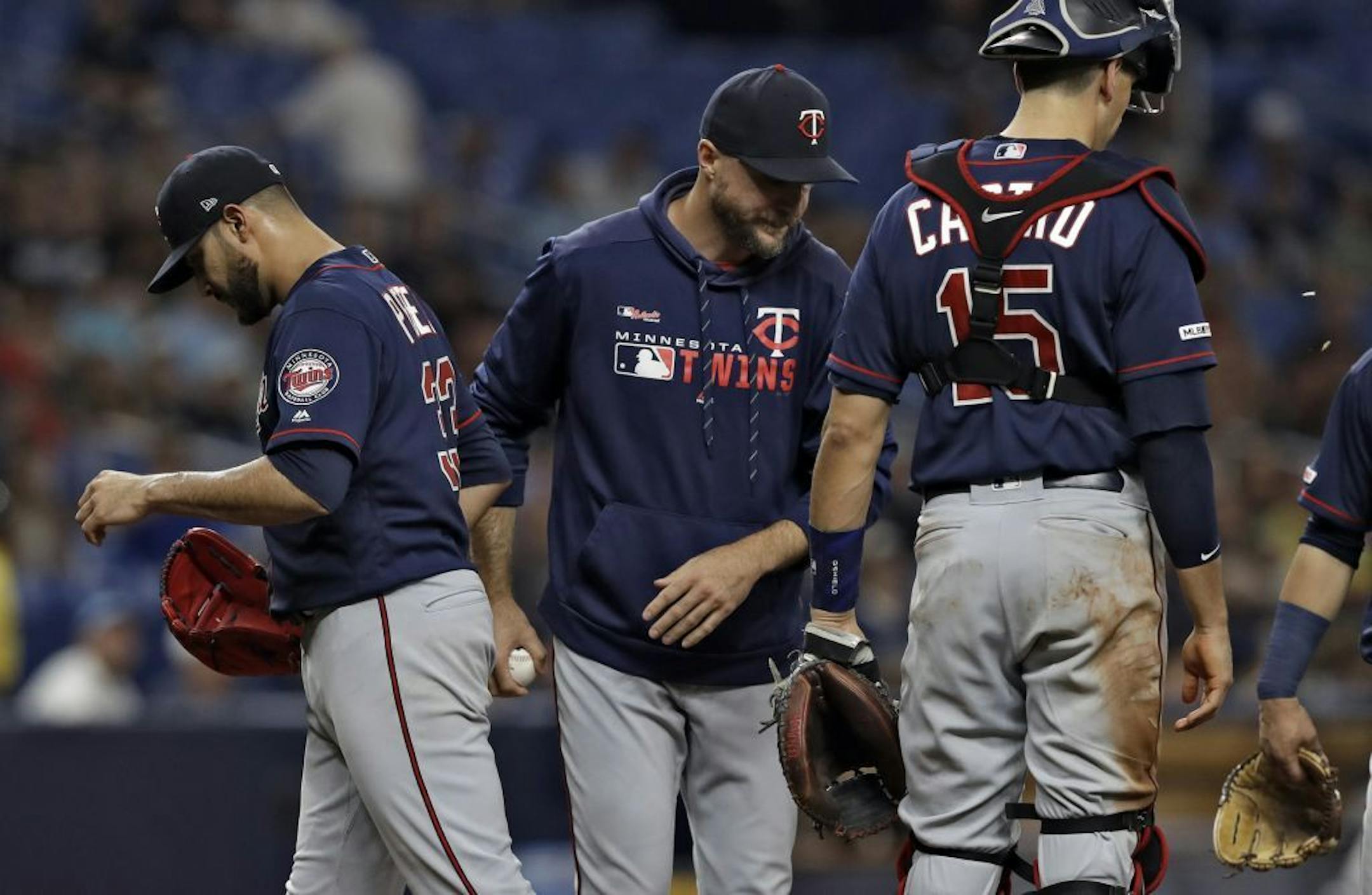 Minnesota Twins manager Rocco Baldelli, center, takes starting pitcher Martin Perez, left out of the baseball game against the Tampa Bay Rays during the third inning Thursday, May 30, 2019, in St. Petersburg, Fla. At right is catcher Jason Castro.